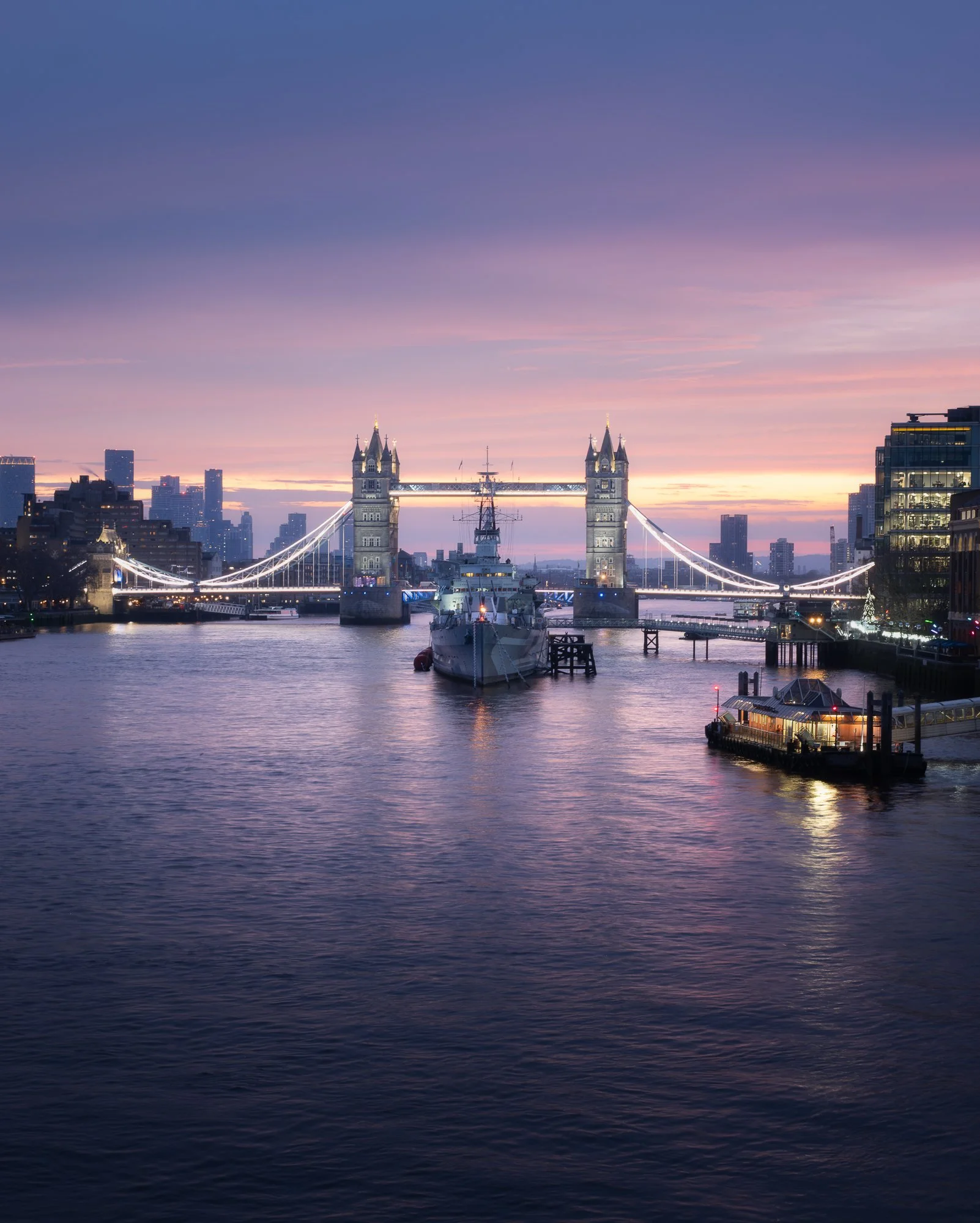 London cityscape at sunrise from London Bridge, featuring HMS Belfast and Tower Bridge