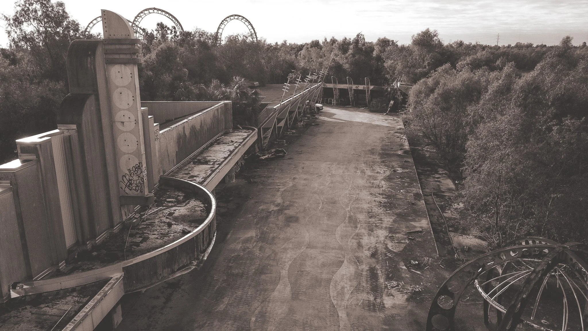 Abandoned amusement park with roller coaster tracks and a decayed ride in a wooded area. the abandoned Six Flags New Orleans Jazzland. This iconic, world-famous park was devastated along with the city of New Orleans during Hurricane Katrina.