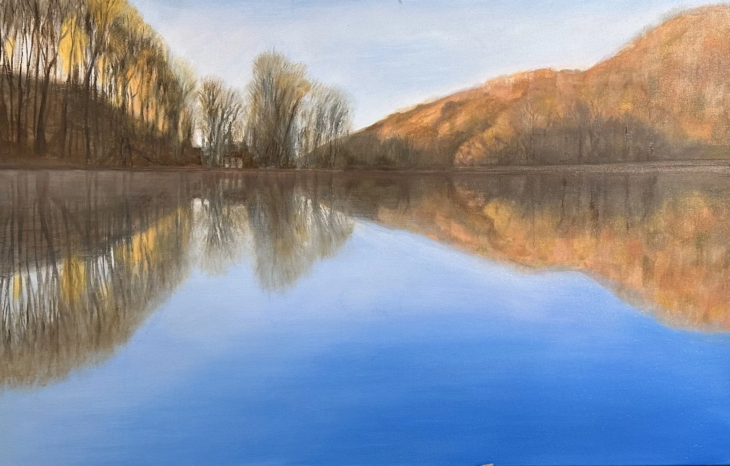 Serene landscape painting of a river bending around grassy banks with lush green trees in the background under a cloudy sky.