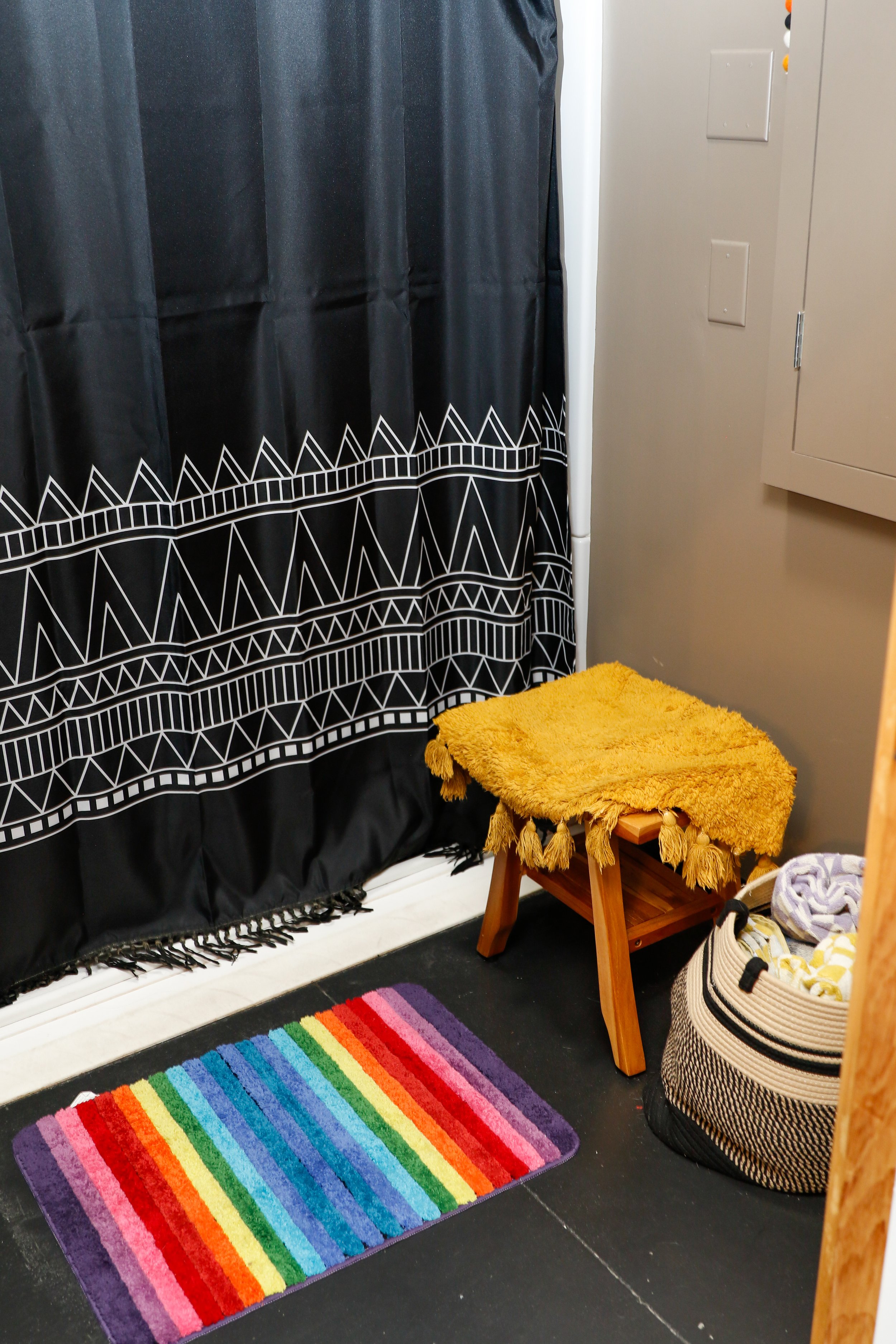 The shower room equipped with a seat and towels  