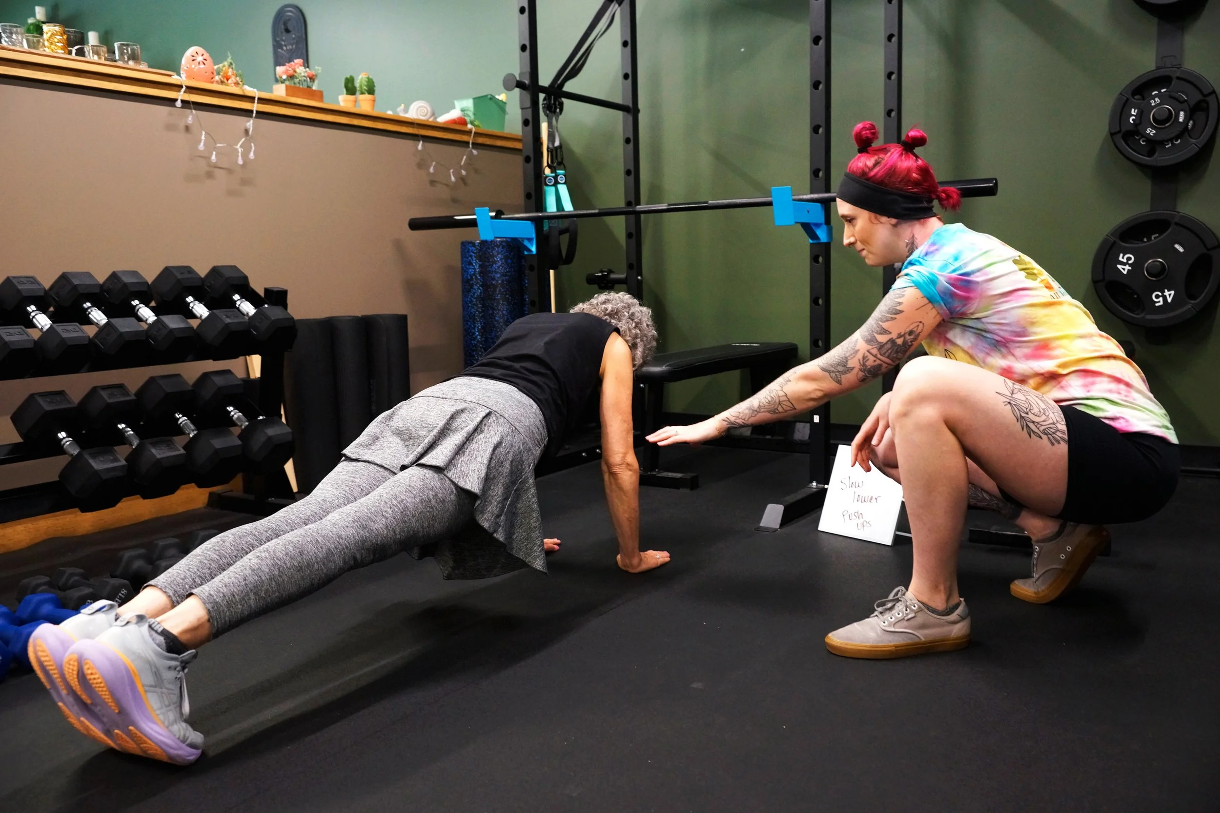 Trainer coaching a woman on her push up in Hadley MA