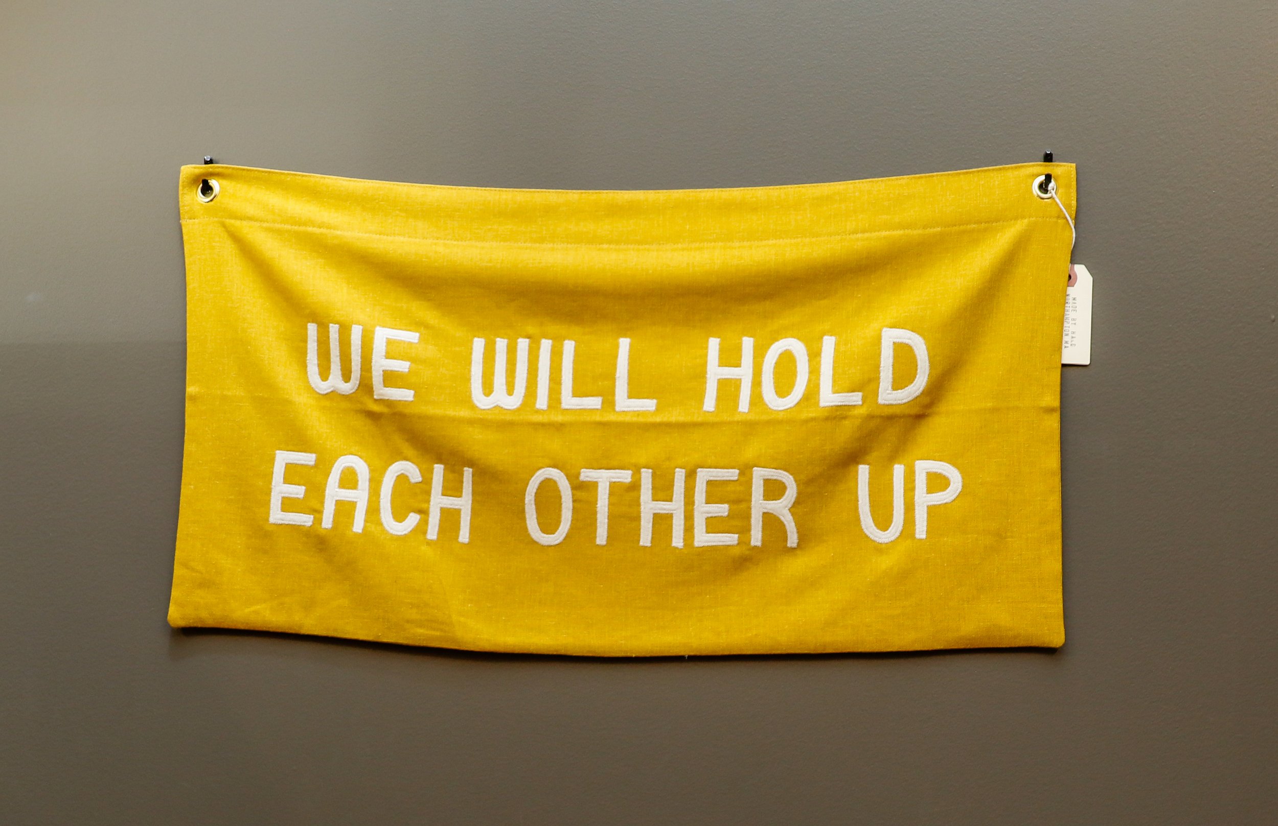 A banner expressing that we will help hold each other up