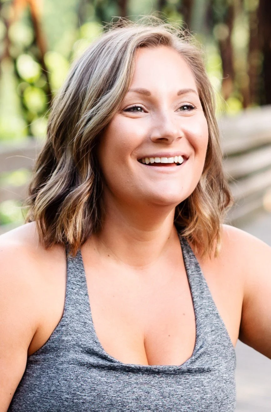 A woman with sandy hair cut into a bob smiling with looking off camera