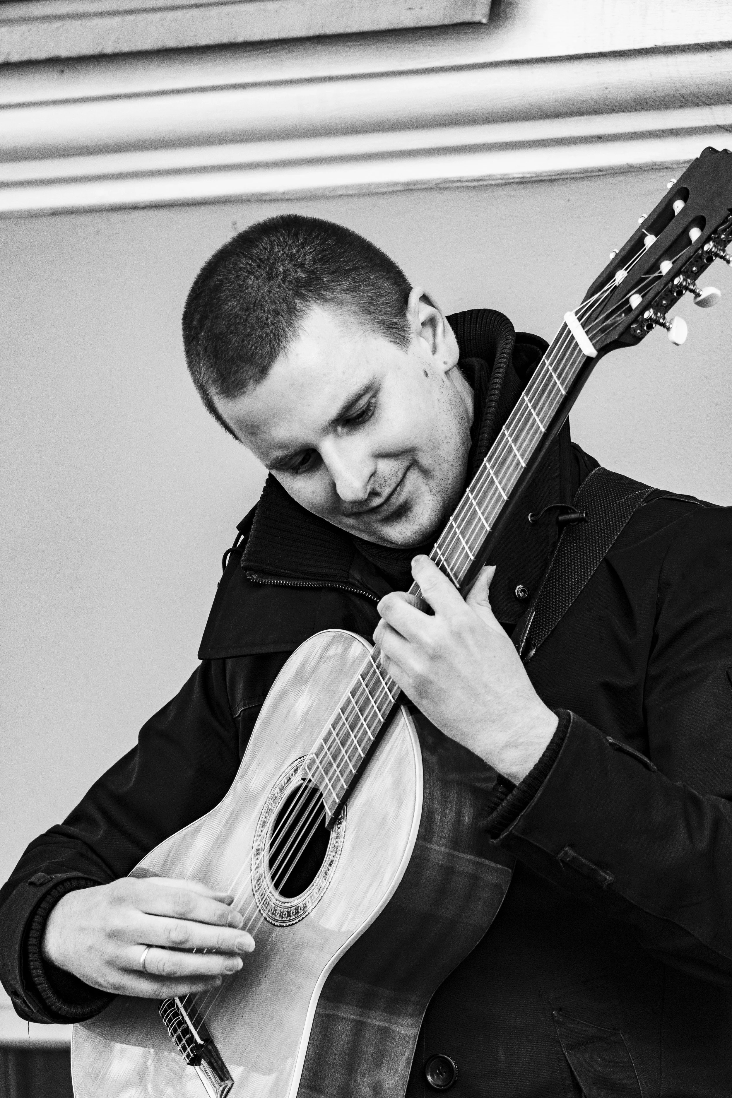 Young man playing an acoustic guitar.
