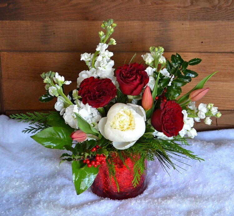 ..............................
Santa Baby! ❄️ 
This premium floral arrangement is packed in an elegant mercury glass vase - filled with  red heart roses, white peonies, red tulips, white stock, fresh holly, and Christmas Greens. This arrangement is a