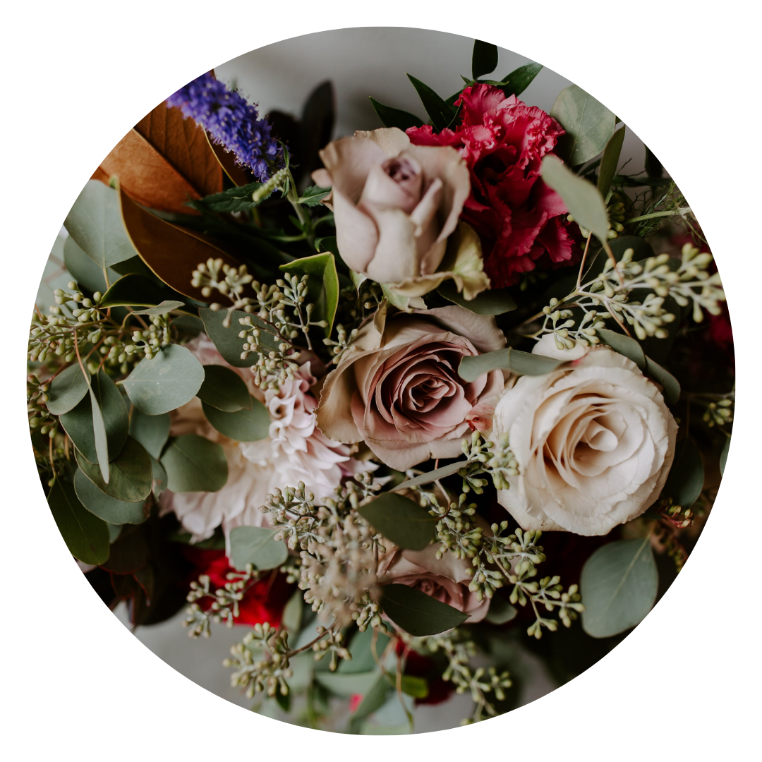 A bouquet of mixed flowers with roses, greenery, and additional floral accents.