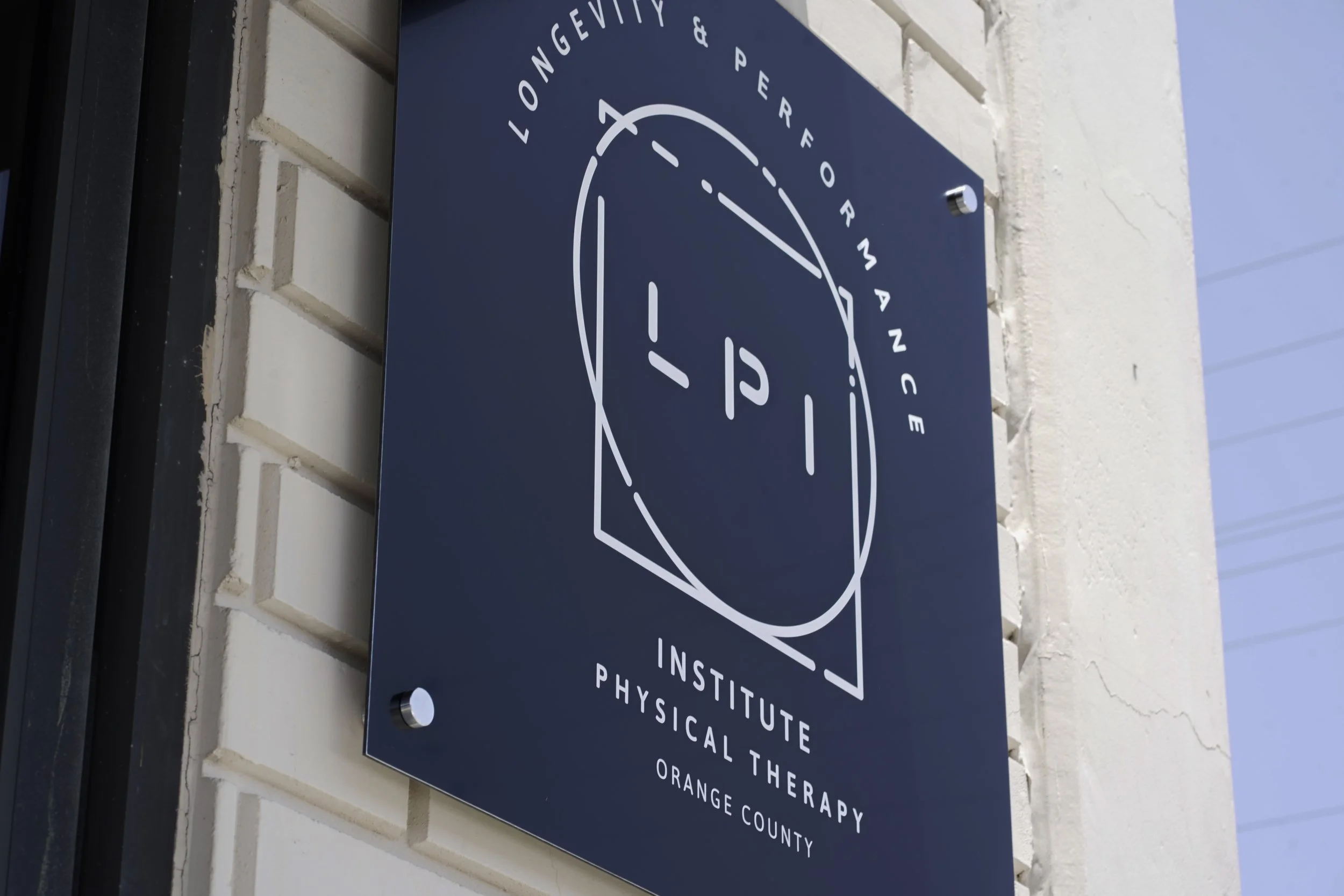 Sign for Longevity & Performance Institute Physical Therapy in Orange County mounted on a wall.