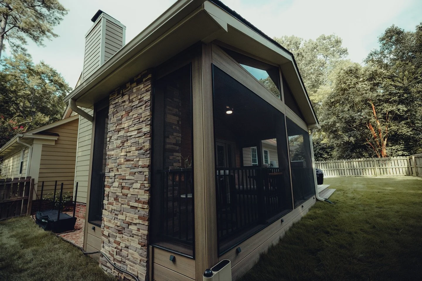 Where cozy meets custom!
This screened-in porch was designed to look like it’s always been part of the home! It comes complete with a fireplace, natural textures, and all the comforts for year-round relaxation. ☀️🌷🍁❄️