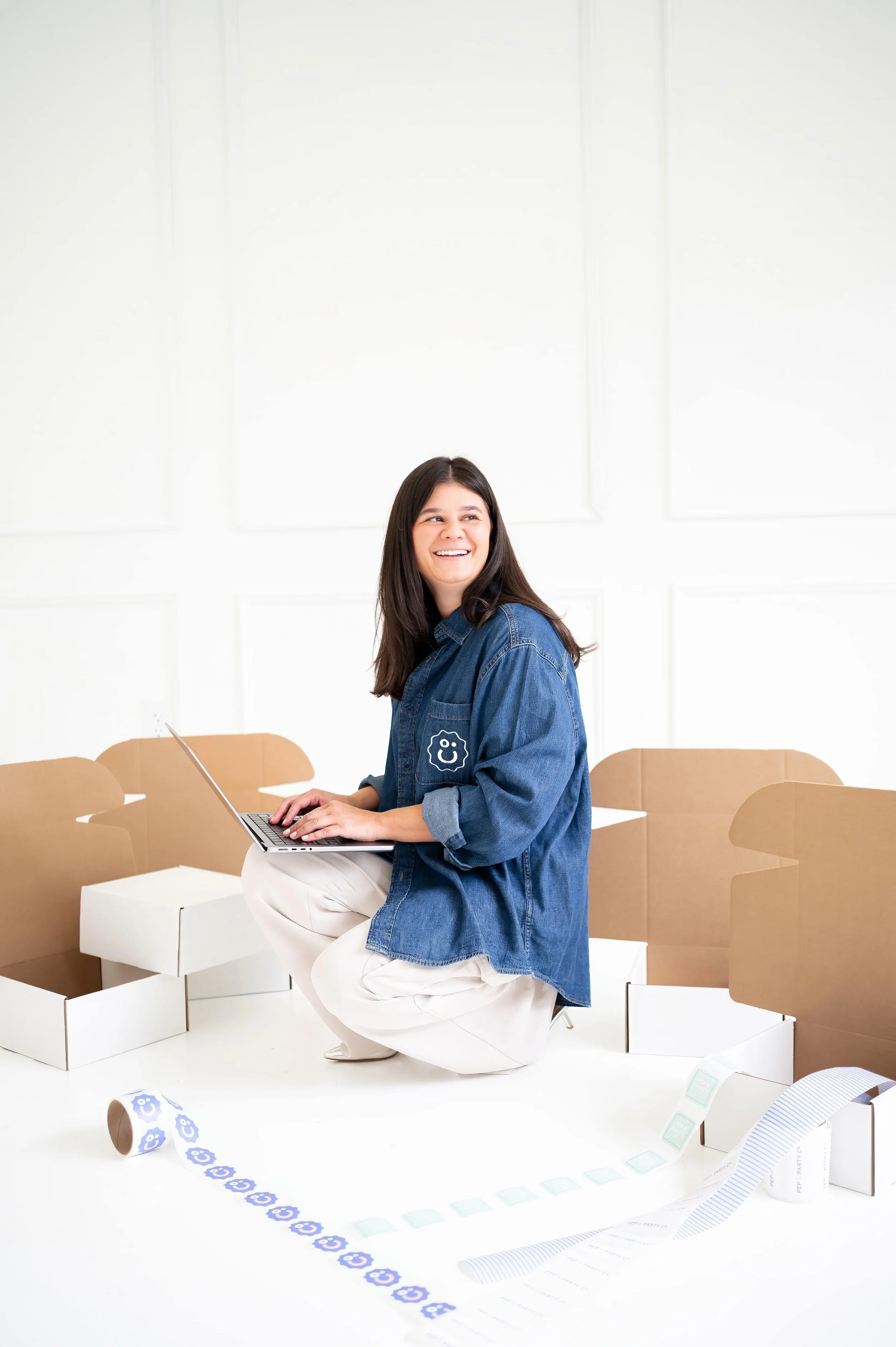 Annie Bradshaw smiling while surrounded by gift boxes and working on corporate gifting orders for clients.