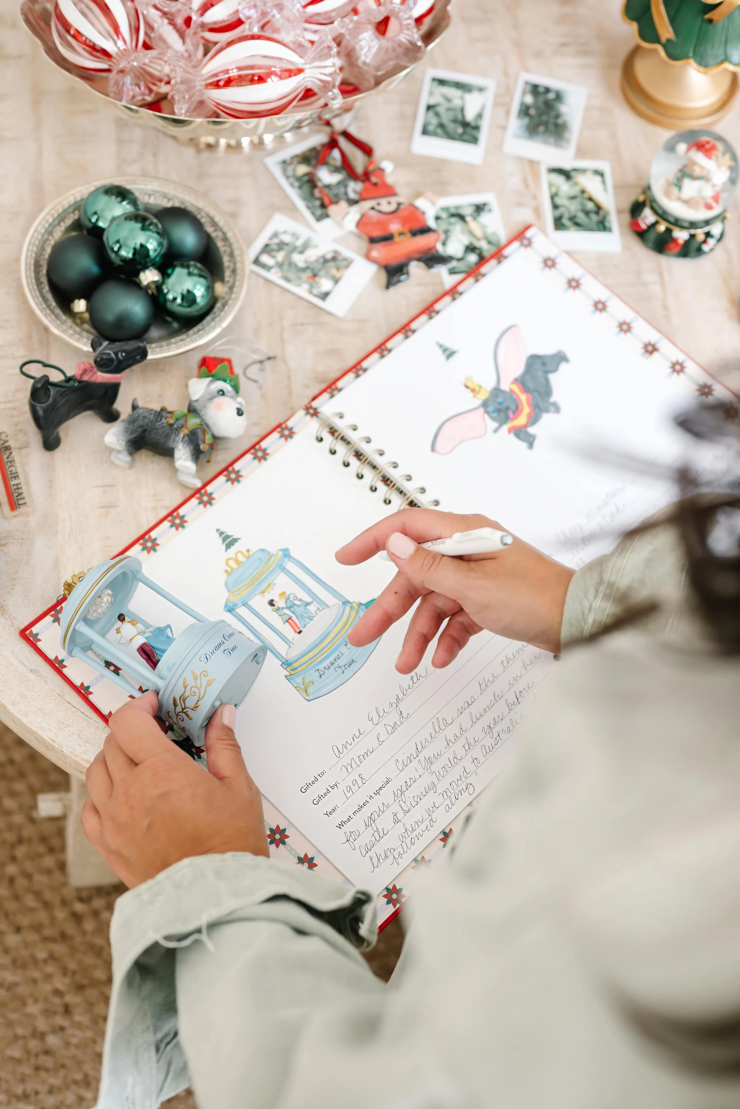 Mom drawing a photo of a Christmas ornament in the Christmas ornament book.