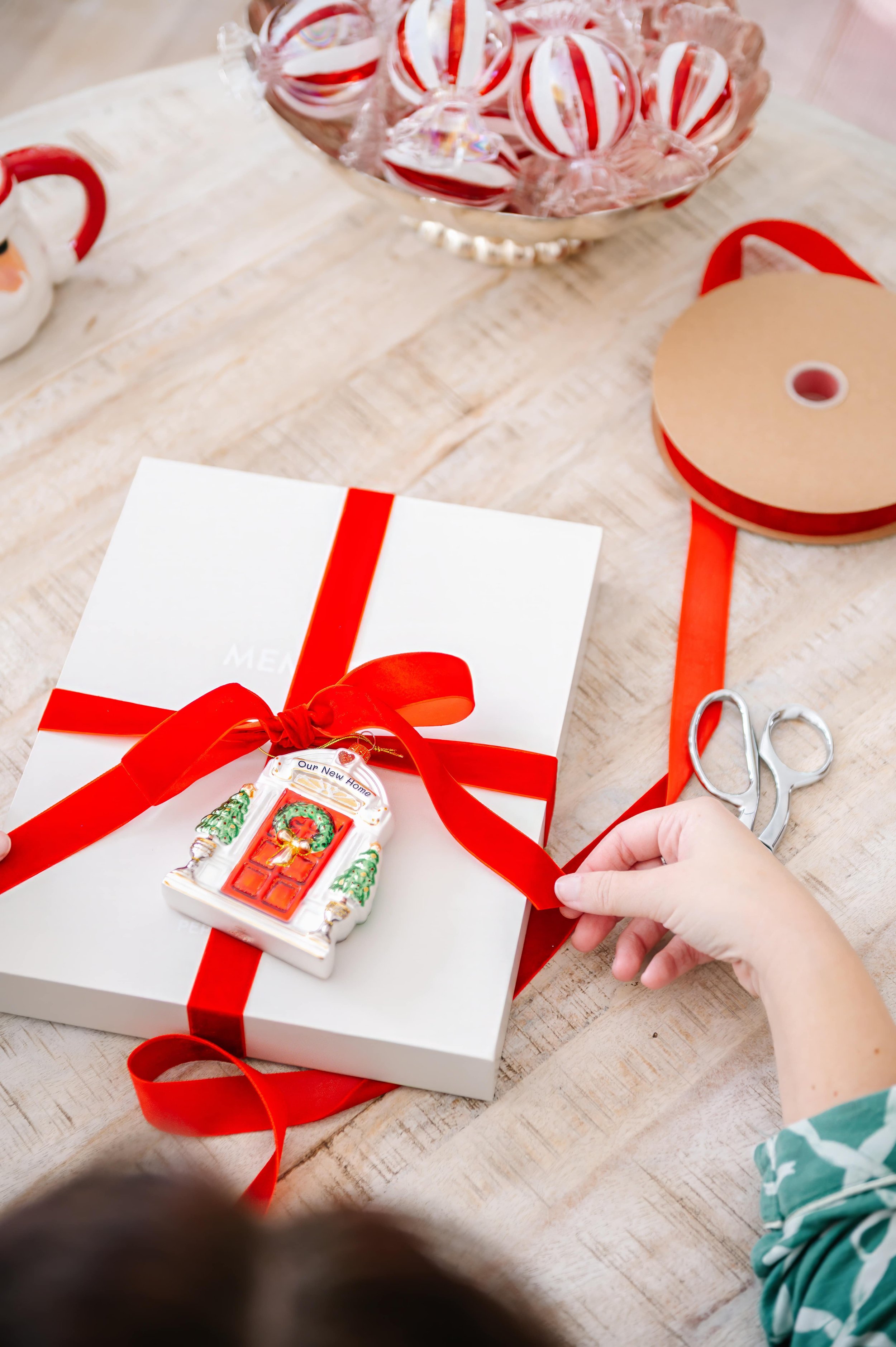 Christmas ornament memory book packaged in a gift box with a red ribbon.