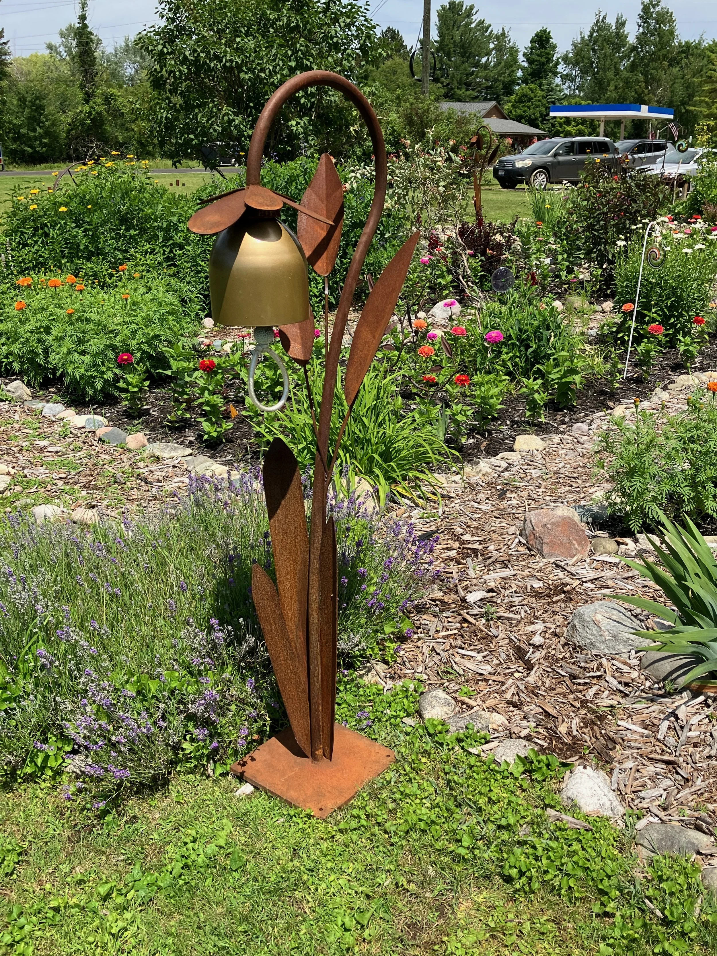 Single Golden Flower  on a weathered steel stand, at Three Pines Gallery 2023
