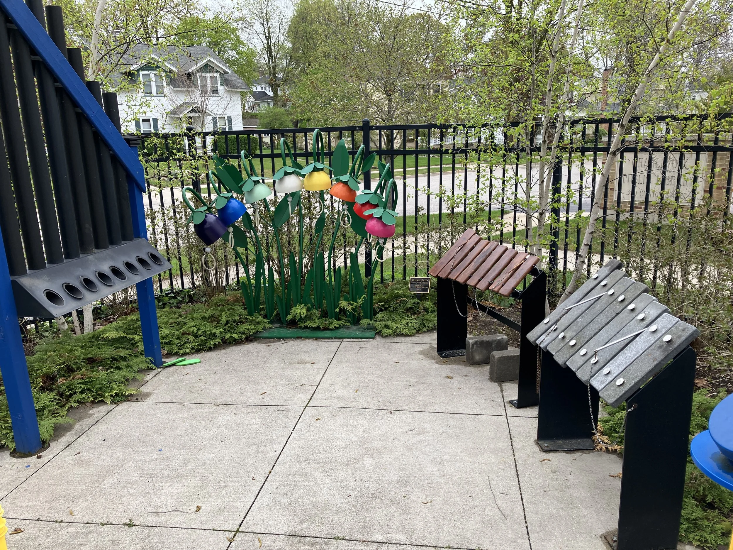 Four instruments, all tuned to a C major scale, so they can be played together, at the Charlevoix Michigan Public Library Children's Garden. From left to right; Slap Tubes, KinderBells, an Amadinda (xylophone), and a Lithophone. 