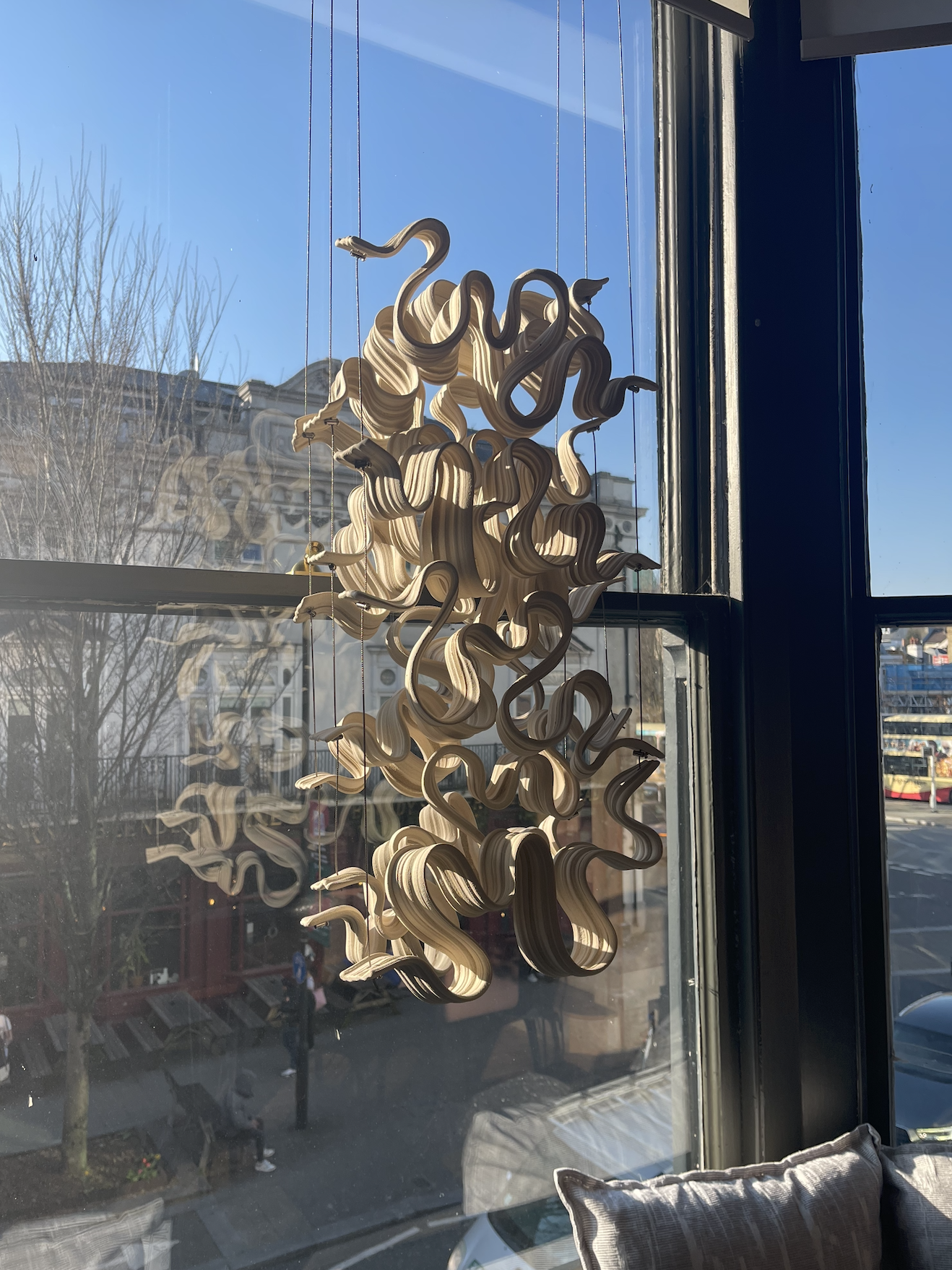 A drawing of a butterfly made of collage-style paper pieces with handwritten text that says 'welcome home', butterflies, hearts, stars, and flowers, floating above a cityscape at night with clouds and a starry sky.