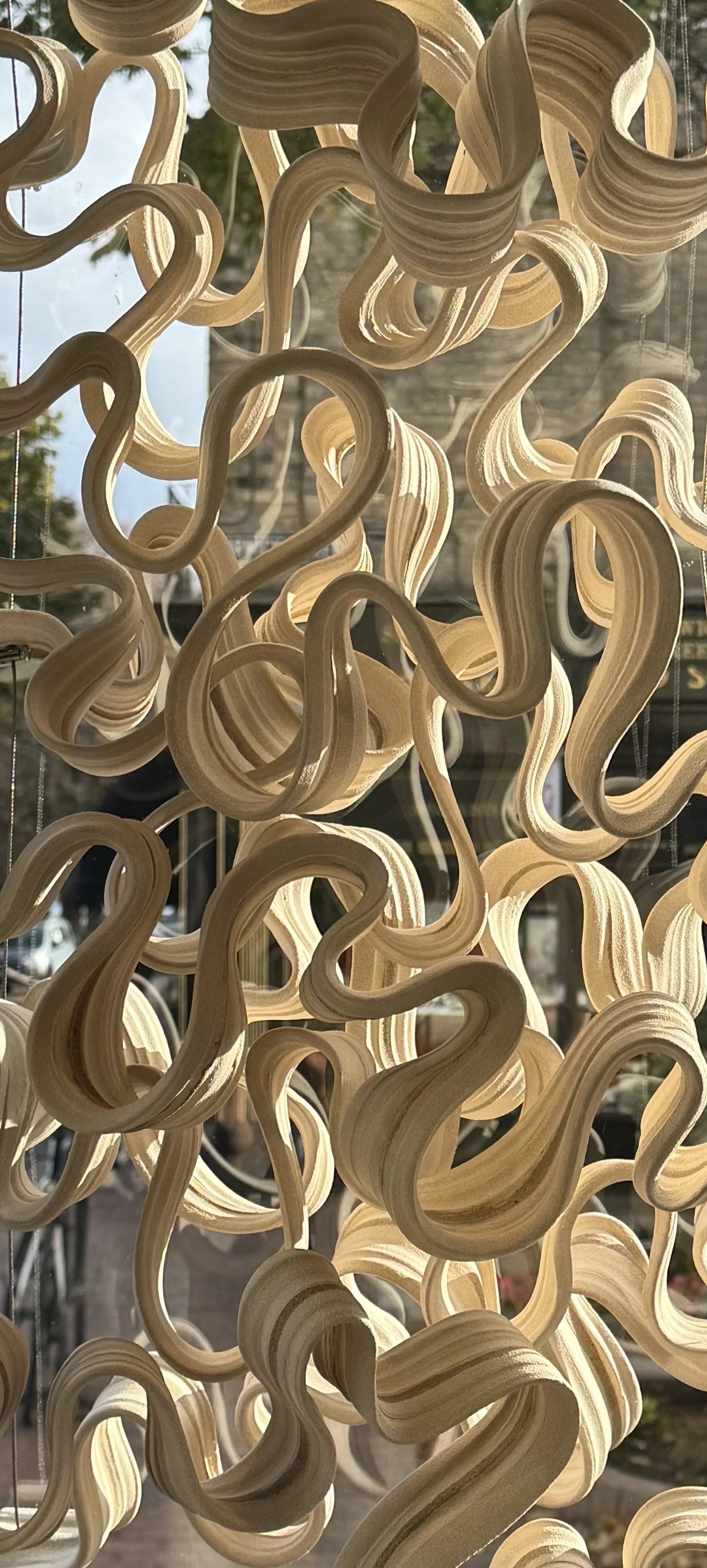 A drawing of a butterfly made of collage-style paper pieces with handwritten text that says 'welcome home', butterflies, hearts, stars, and flowers, floating above a cityscape at night with clouds and a starry sky.