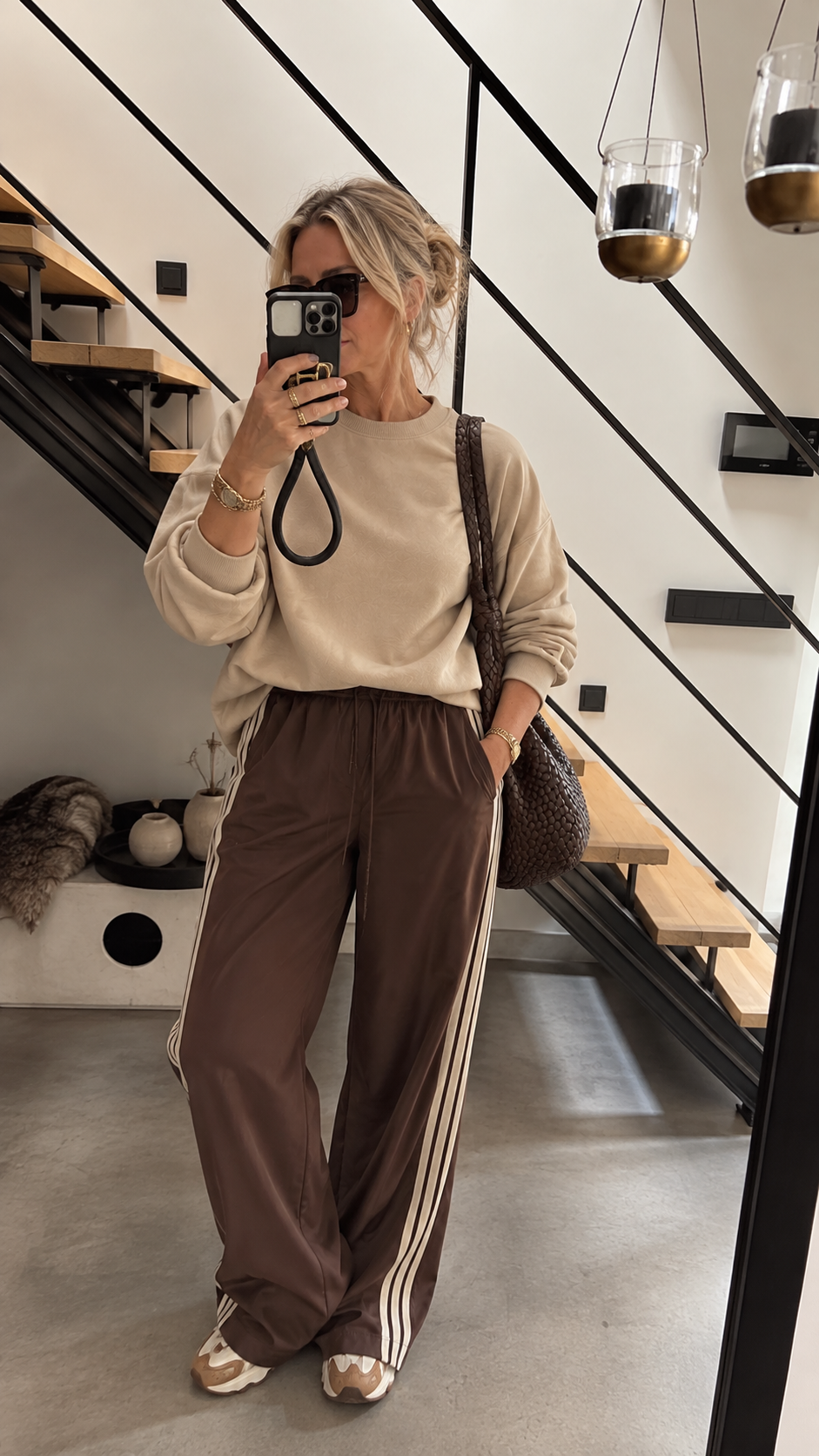 Bruine trackpants gecombineerd in een casual chique herfstlook, geïnspireerd op de sporty modetrend van 2026.