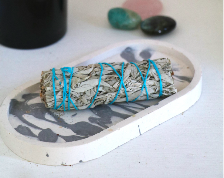 Bâton de sauge posé sur une table, utilisé pour les rituels de purification des orgonites