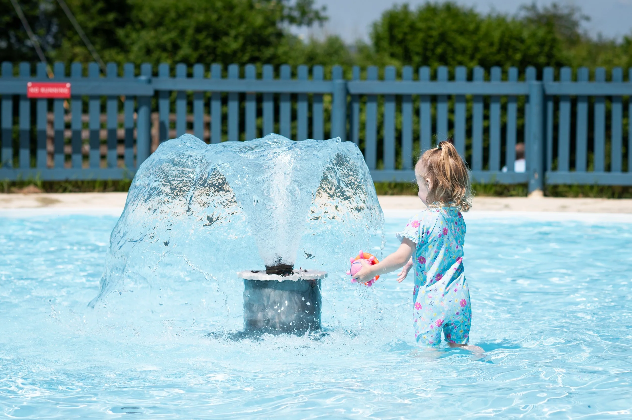 girl playing in pool with fountain