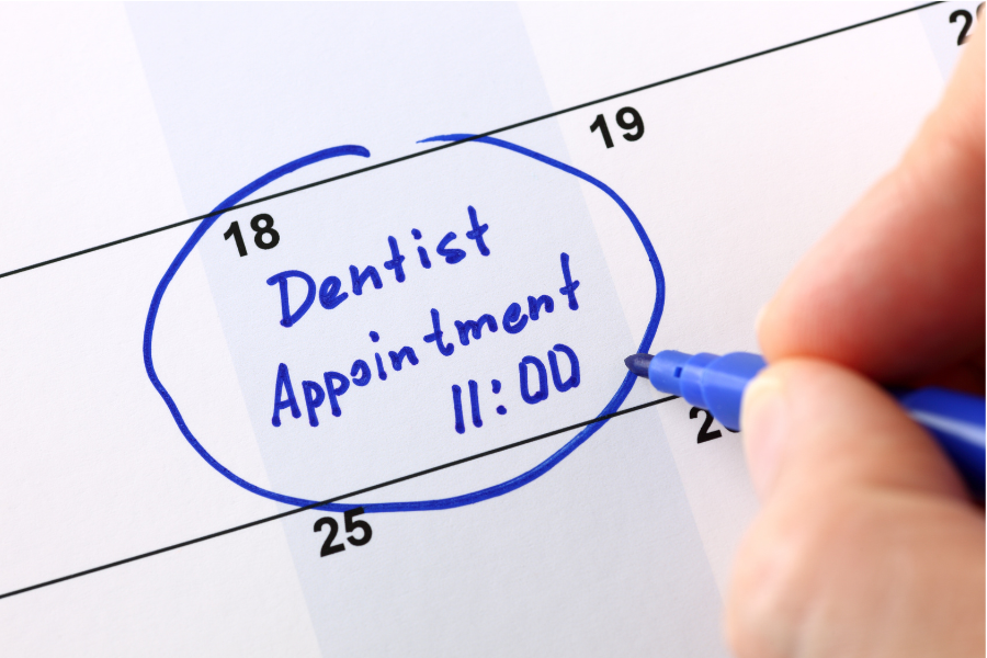 photograph of a calendar page with the words "Dentist Appointment 11:00" circle in blue sharpie pen