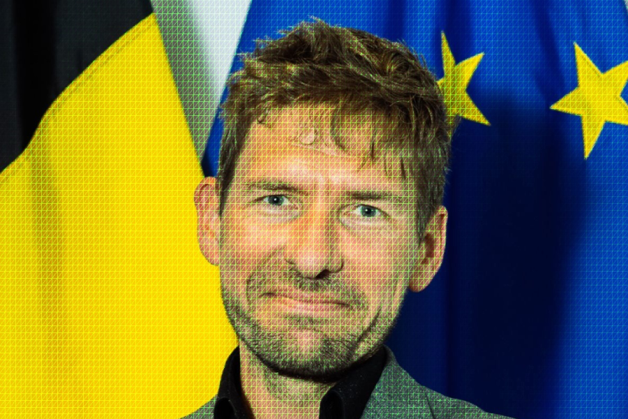 Een foto van Michael voor een Belgische en een Europese vlag. Over de foto ligt een groen cybergrid.