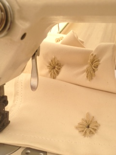 Close-up of fabric with beige flowers, possibly part of a sewing or embroidery project.