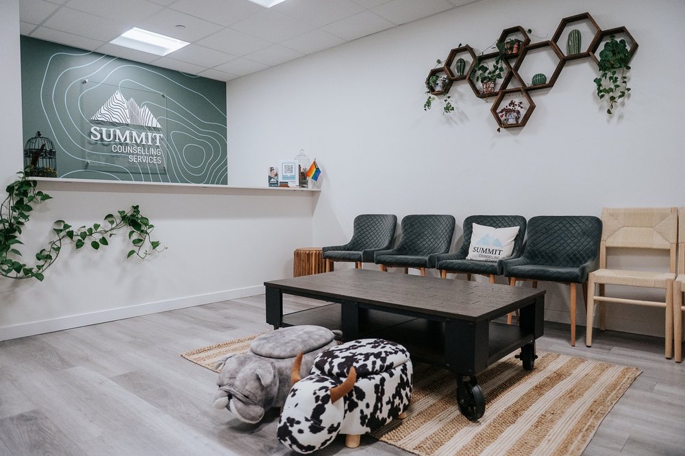 Summit Counselling St. Albert waiting room — warm, welcoming, with plants and the Summit logo on the wall