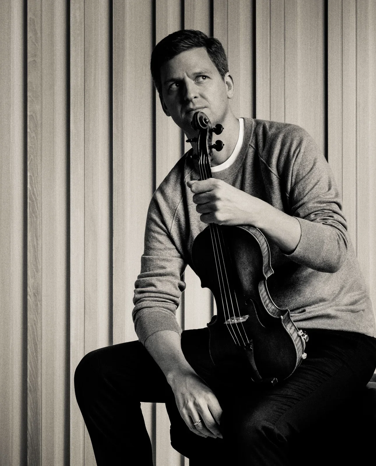 Man in formal attire holding a violin.
