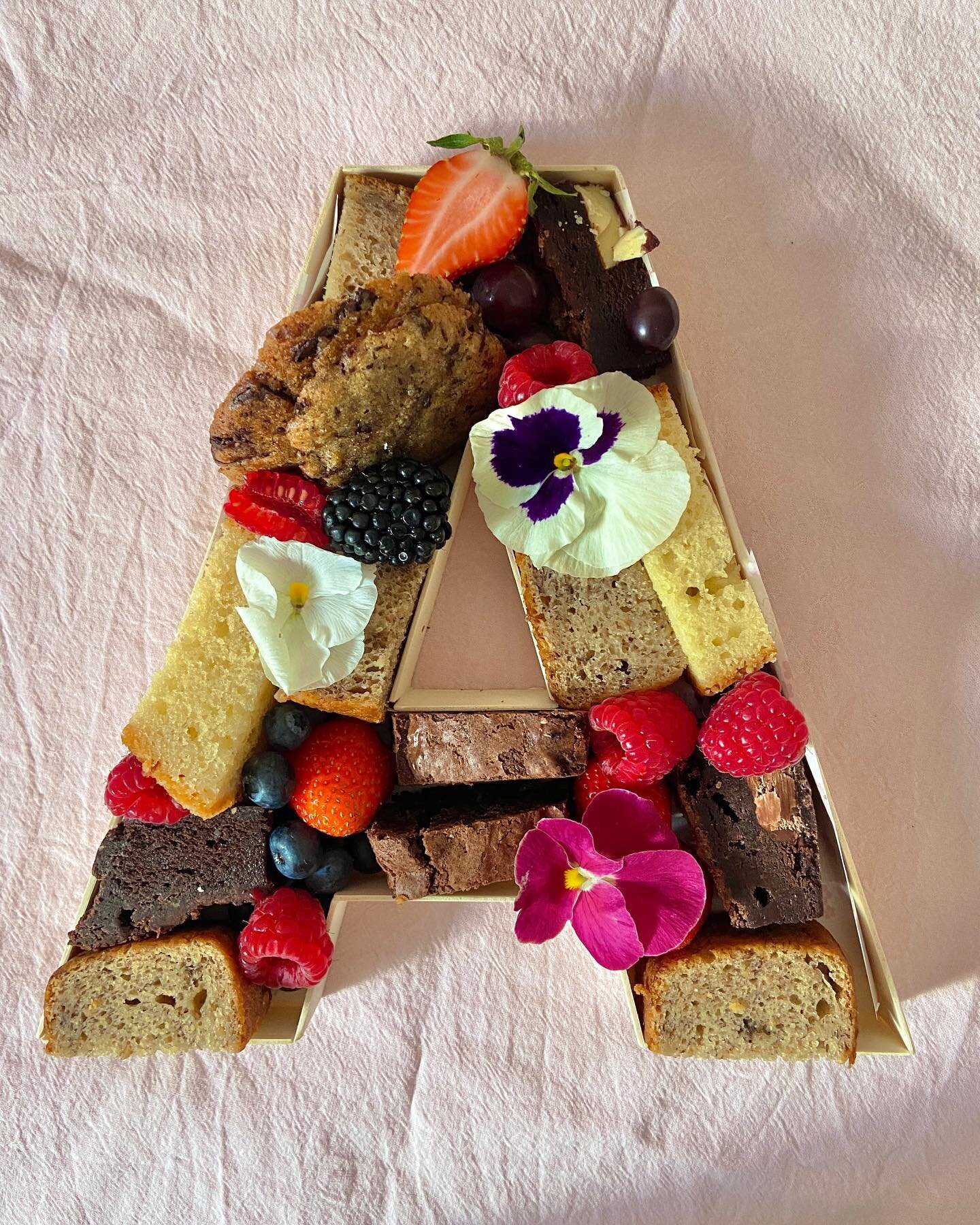 the sweetest bespoke dessert letters 💖 

bamboo letters filled with home baked goodies including triple choc brownies, dark choc chip cookies, banana bread and lemon drizzle. 

decorated with berries and edible flowers 🌸 i&rsquo;m so obsessed!!
