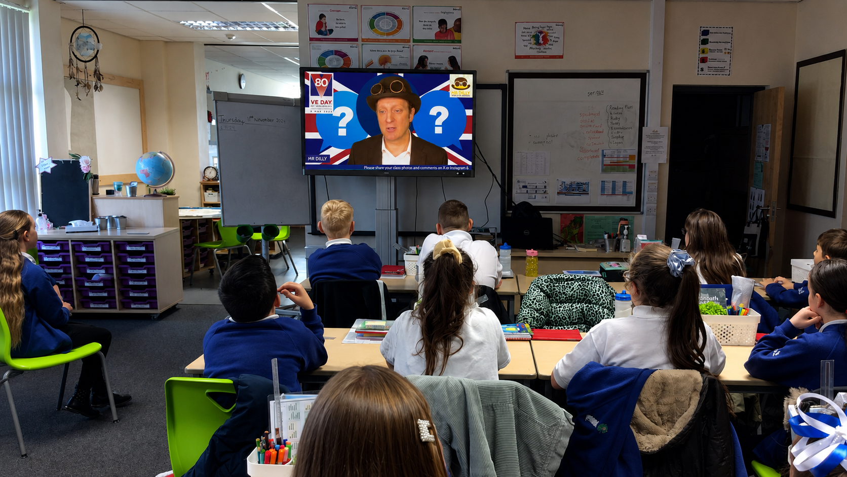 Pupils in a classroom watching Mr Dilly’s virtual WWII history visit, with a Union Jack and Second World War quiz displayed on screen.