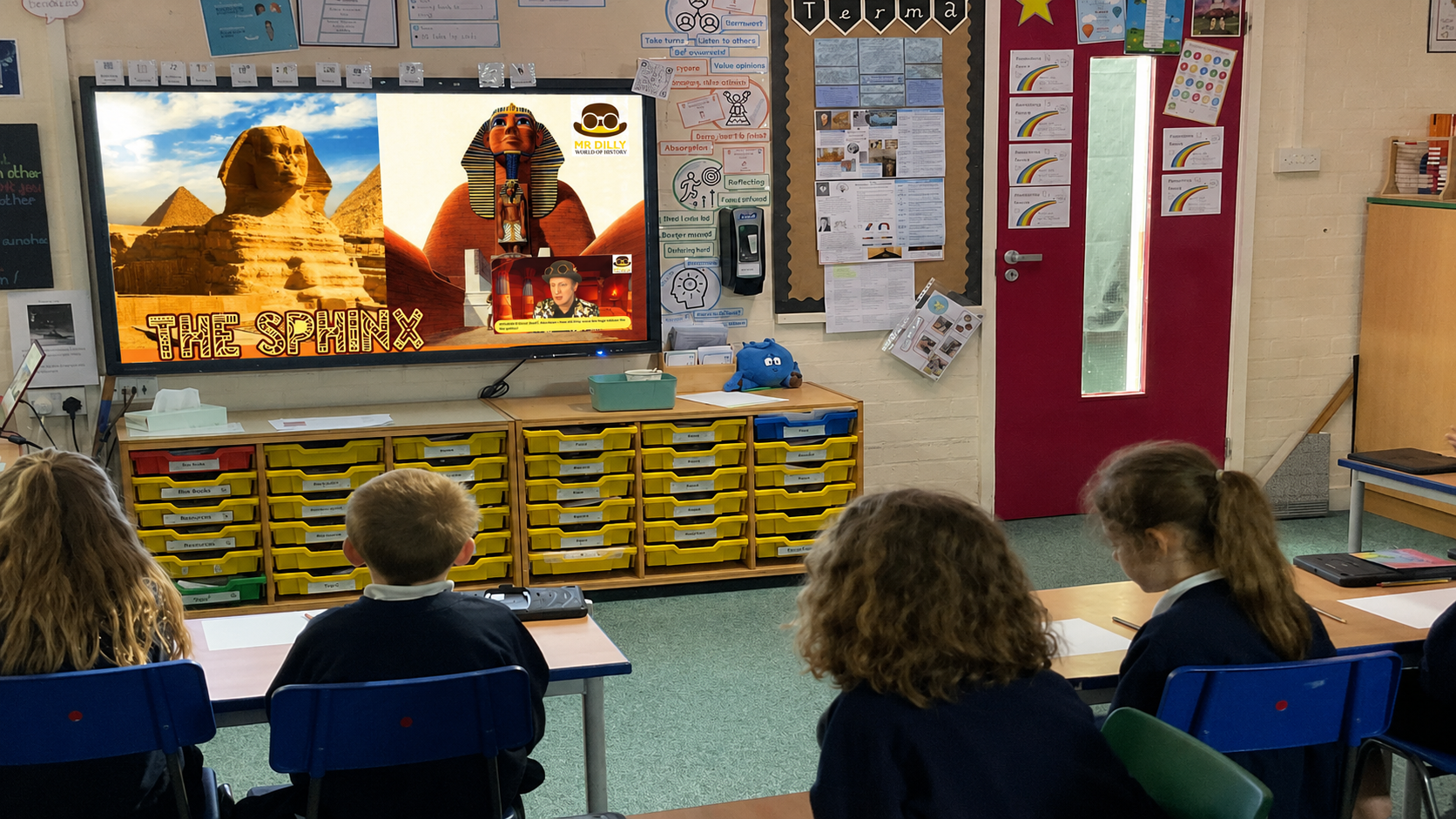 Pupils in a classroom watching Mr Dilly’s virtual Ancient Egypt history visit, with a lesson about the Sphinx displayed on screen.