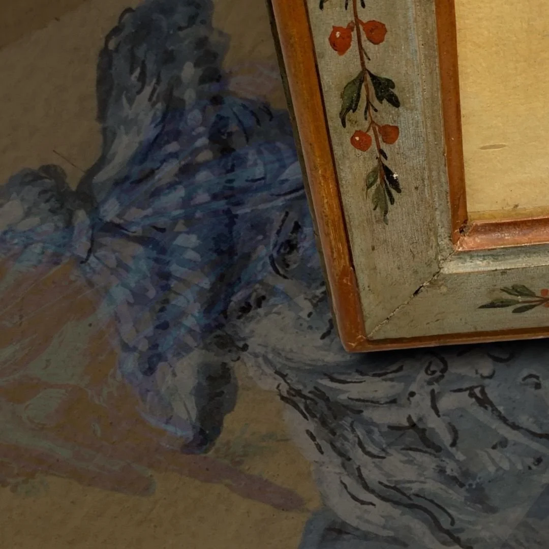 Close-up of a corner of a painted wooden cabinet with orange berries and green leaves, positioned on a patterned fabric with abstract shapes and a diagonal line.