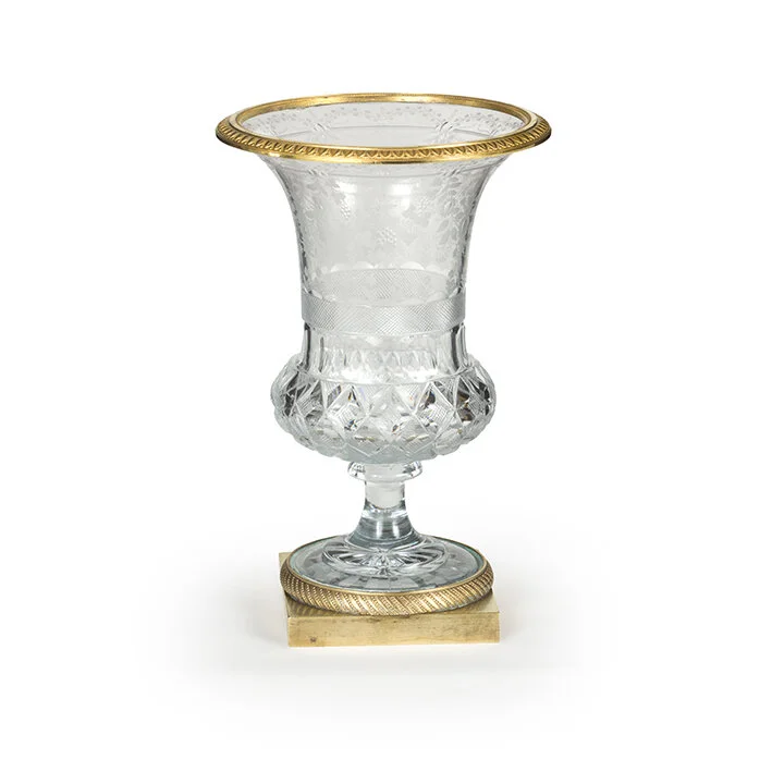 Decorative glass vase with gold accents on a pedestal base.