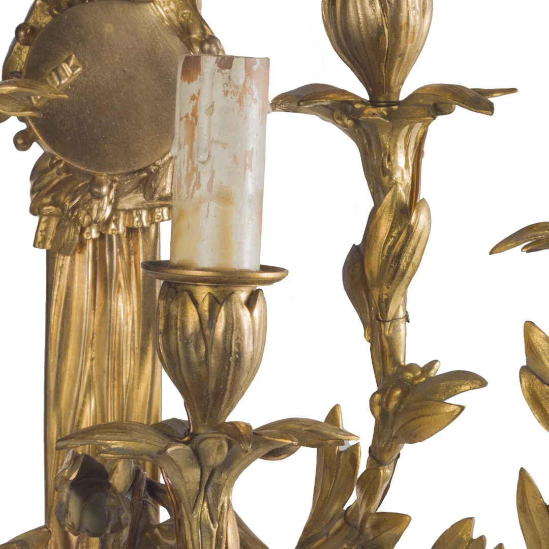 Close-up of a gold-colored ornate candle holder with a single unlit candle placed on it.