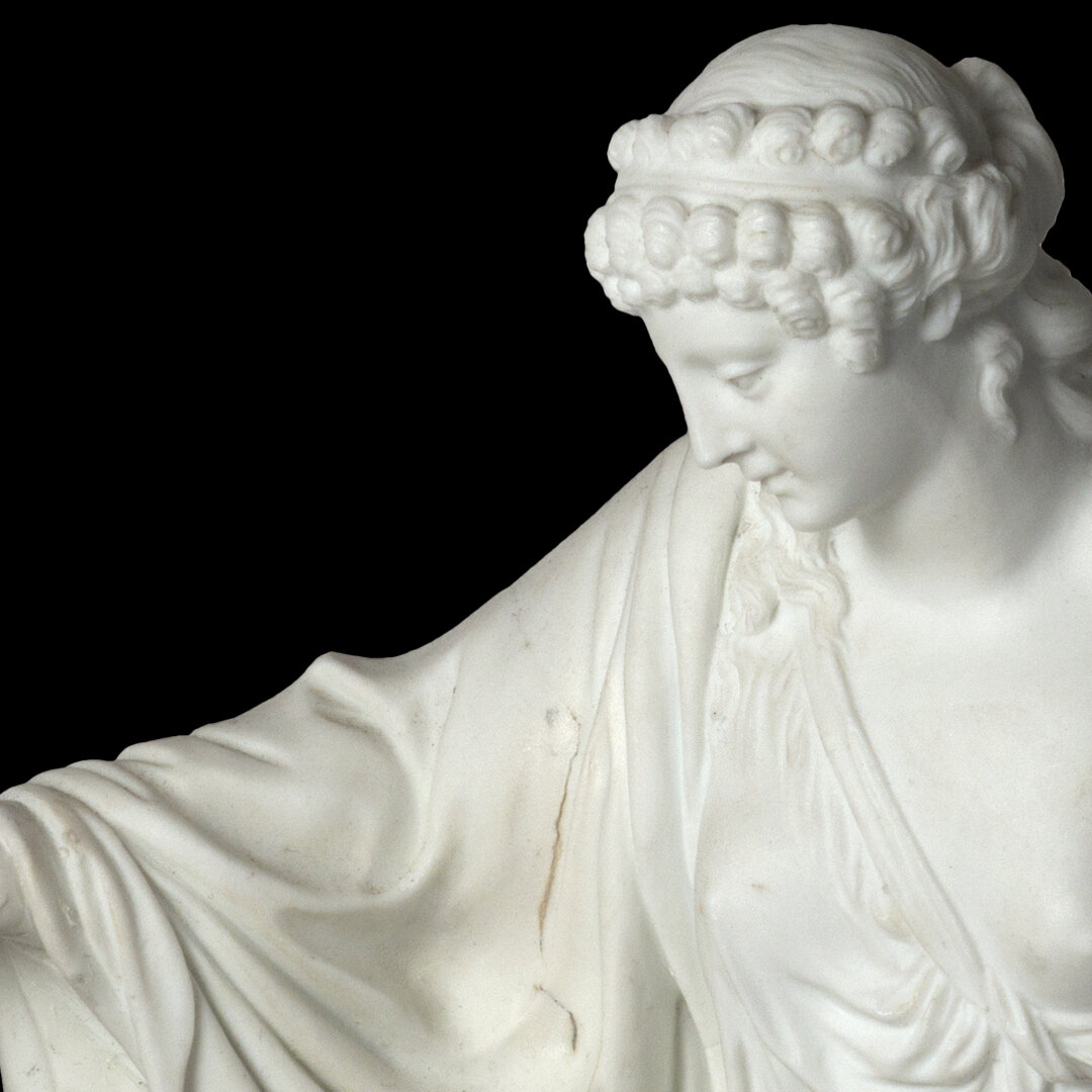 Close-up of a white marble sculpture of a woman with curly hair, looking downward against a black background.