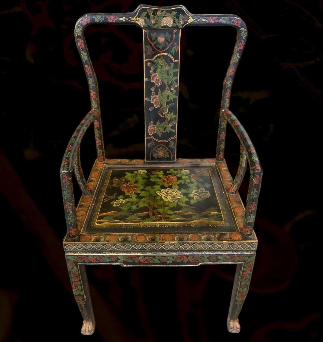 Decorative wooden chair with intricate floral and nature-themed painting, painted in dark colors with gold accents.