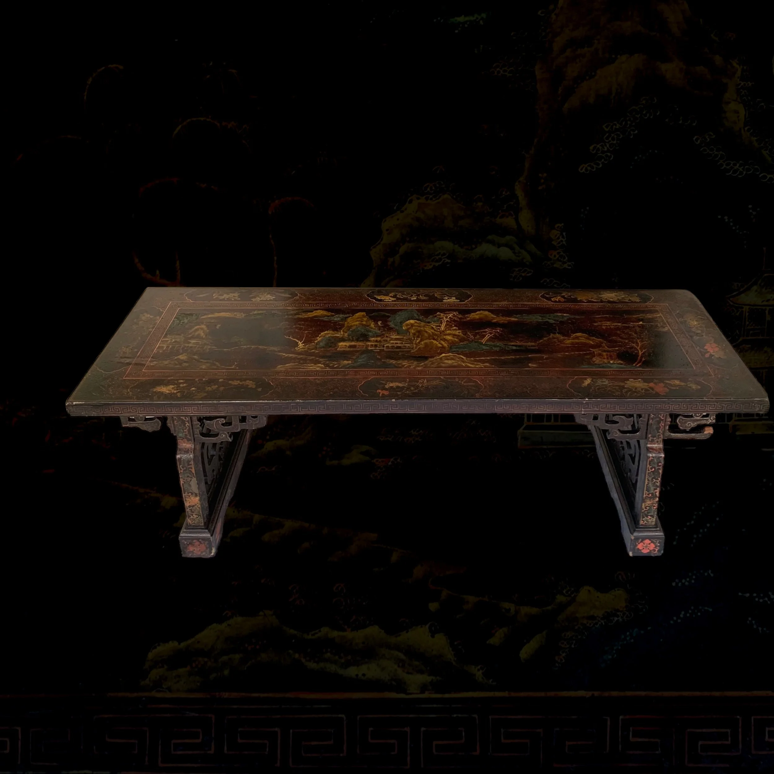 An ornate Asian-style wooden table with detailed painted landscape design.