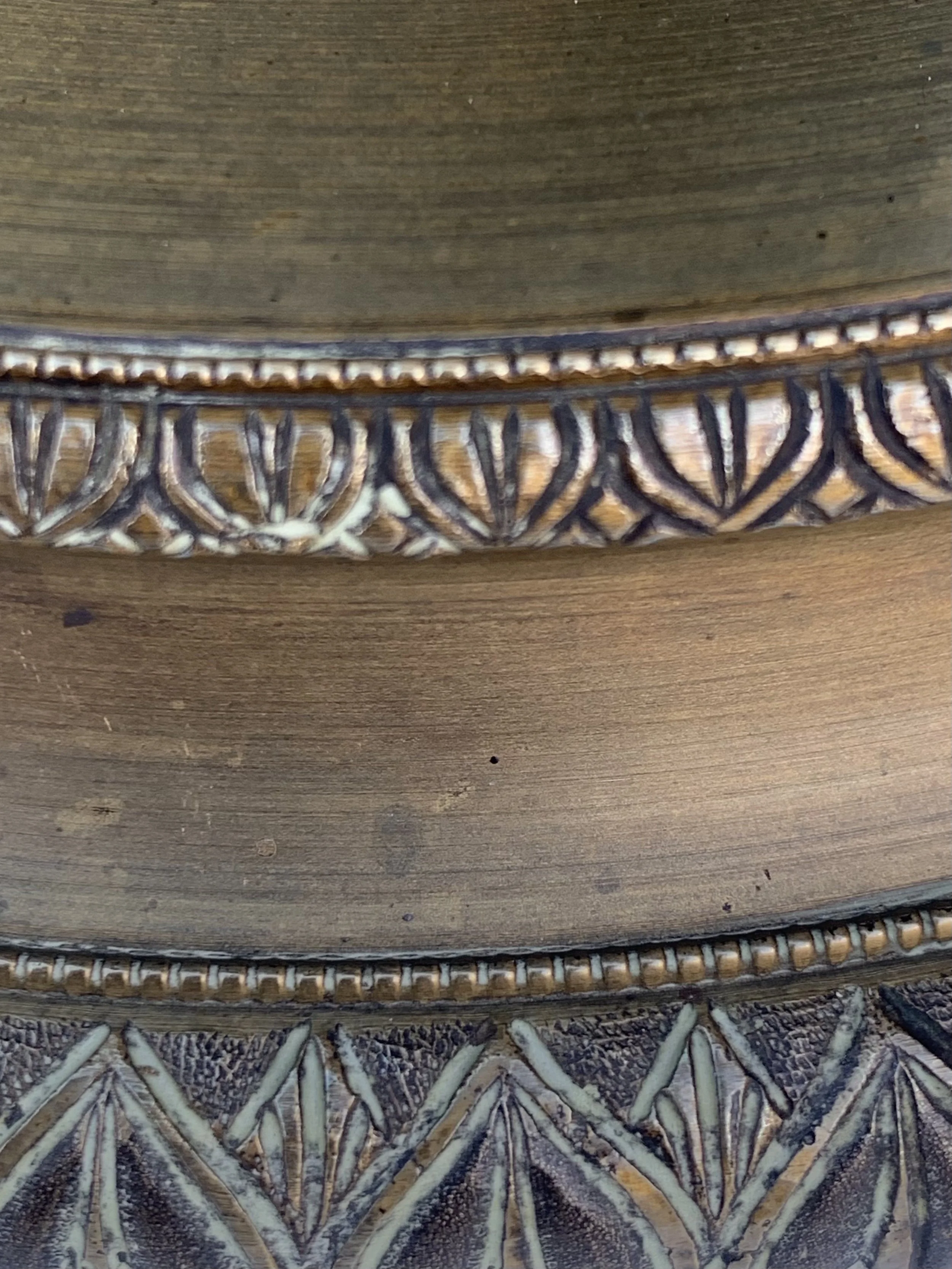 Close-up of intricately carved wooden edges with decorative patterns.