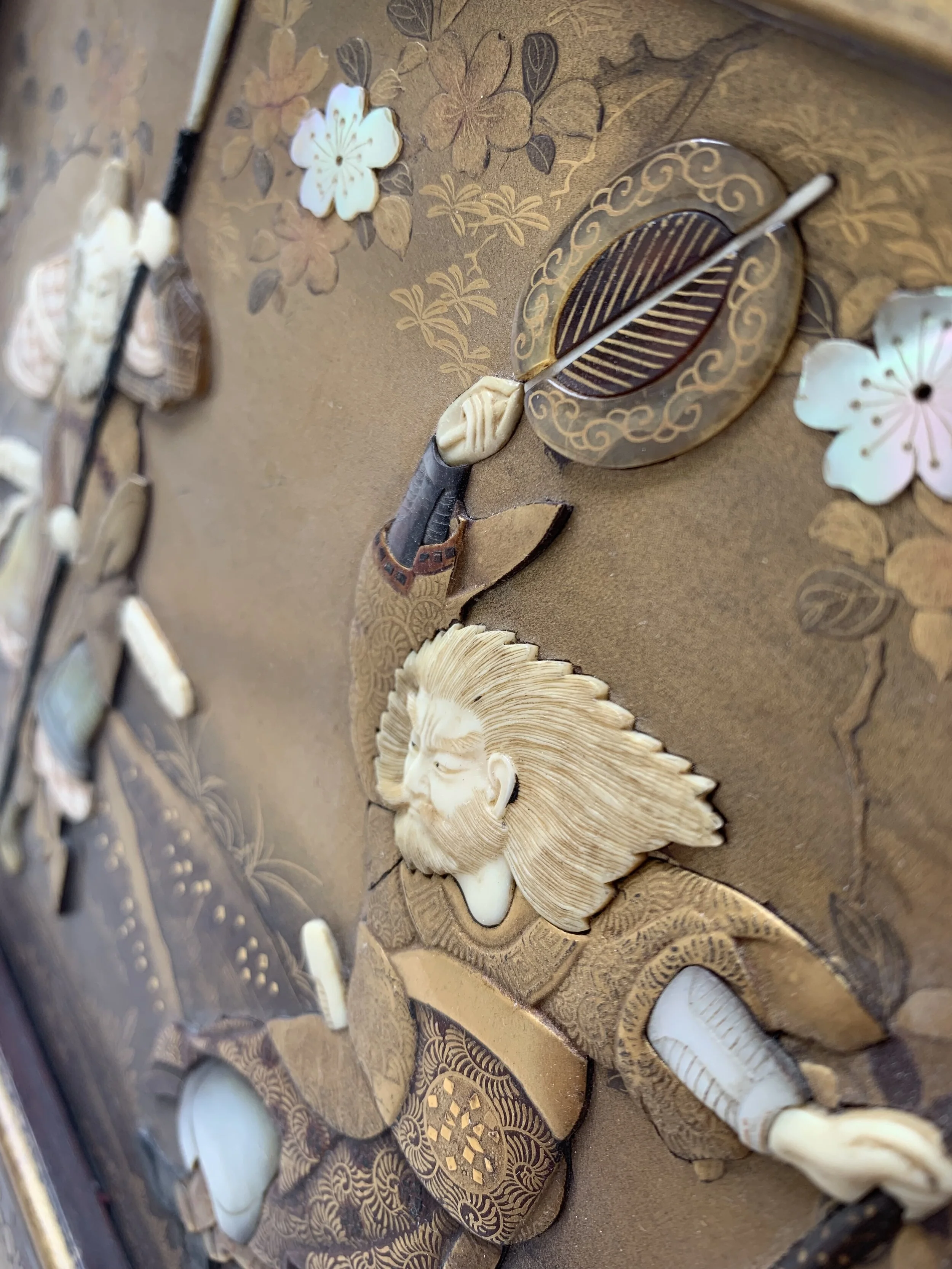 A detailed artwork featuring a samurai warrior with a flowing beard and traditional armor, surrounded by floral patterns and leaves on a textured background.