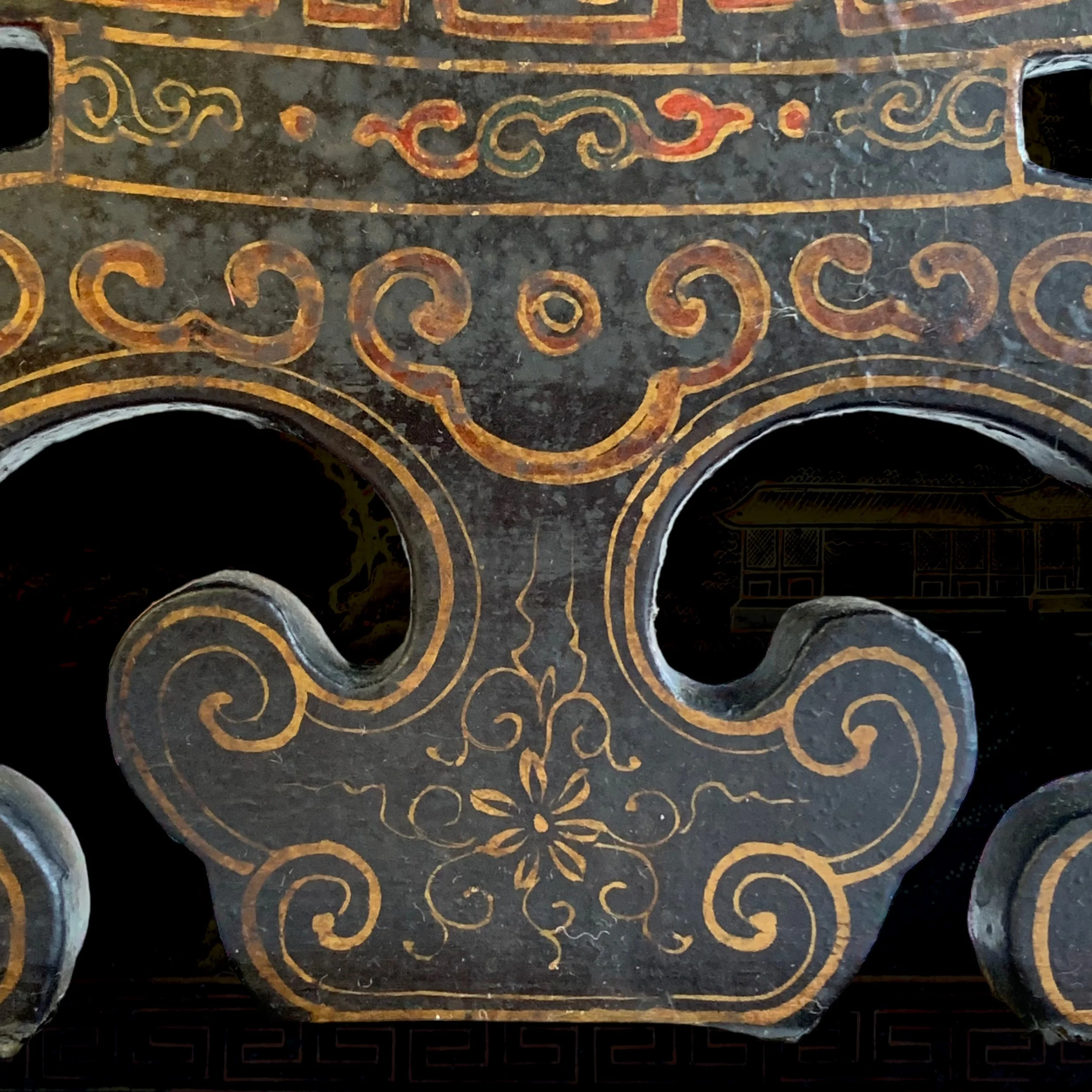 Decorative carved wood panel with intricate gold and red patterns and floral design.