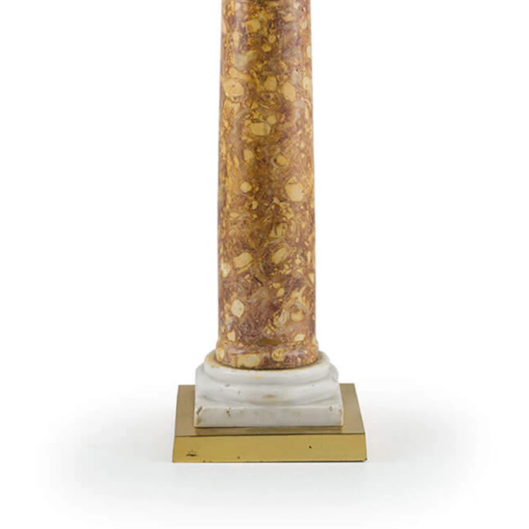 Column made of brown and yellow marble with a white marble base and a gold-colored square pedestal underneath.