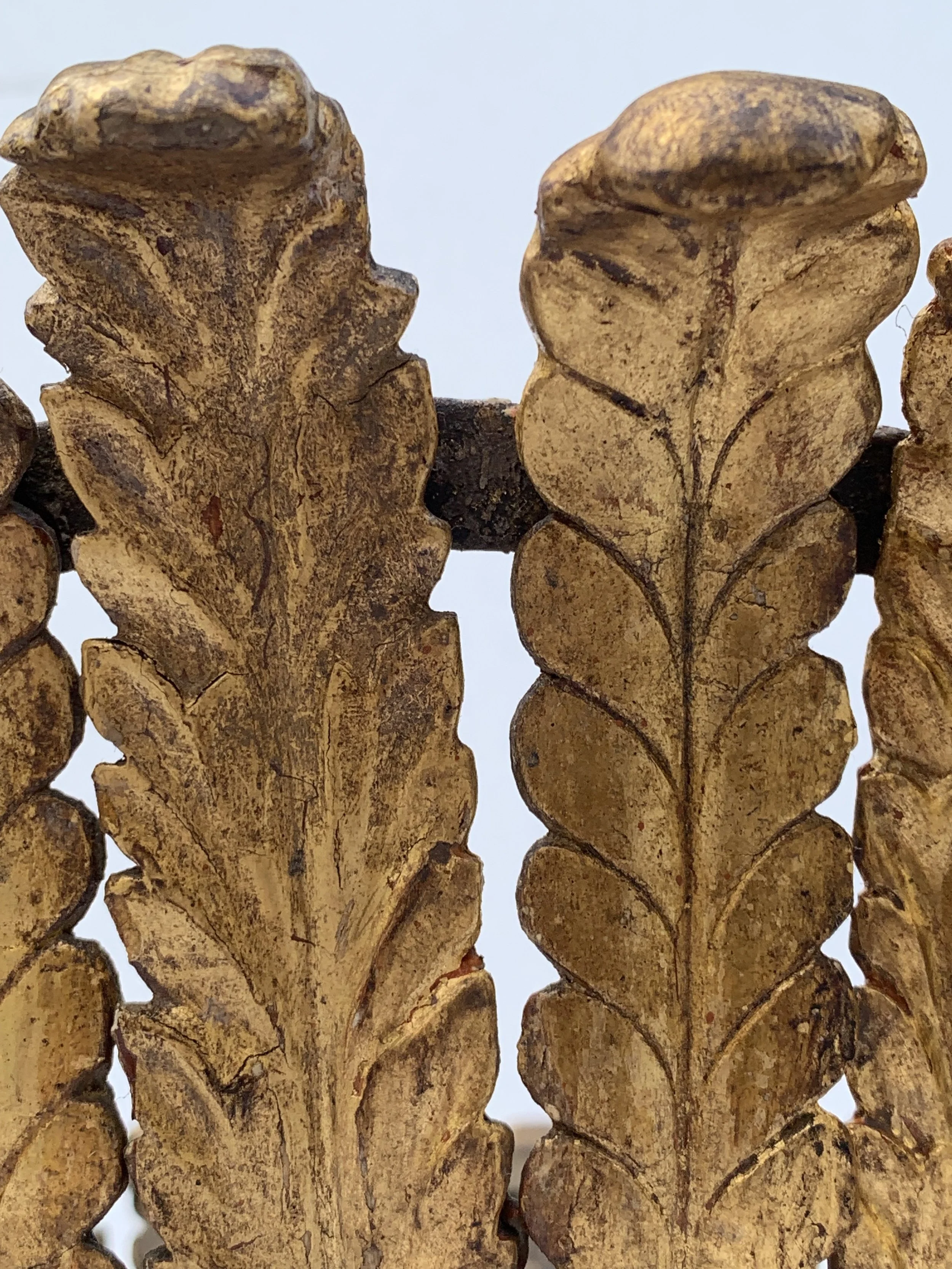 Close-up of two brown, textured, leaf-shaped objects with intricate veining and worn surfaces, possibly carved or manufactured to resemble leaves.