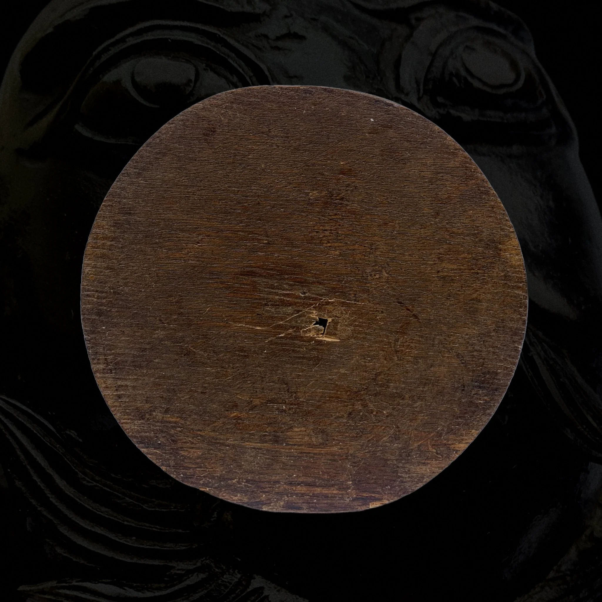 Close-up of a round wooden surface with a small hole in the center