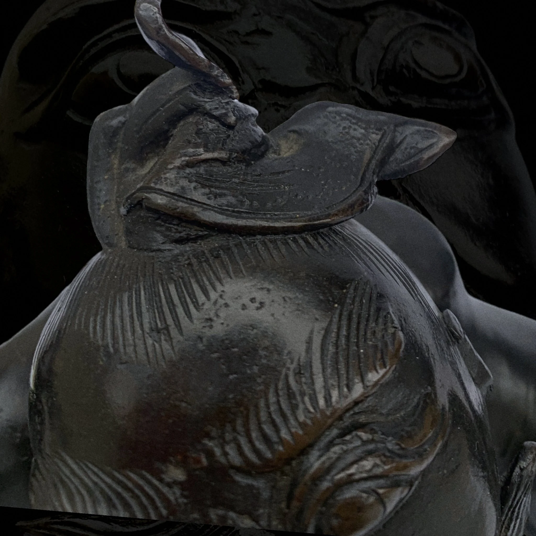 Close-up of an ice sculpture of a fish with detailed carving and textured fins, set against a dark background.