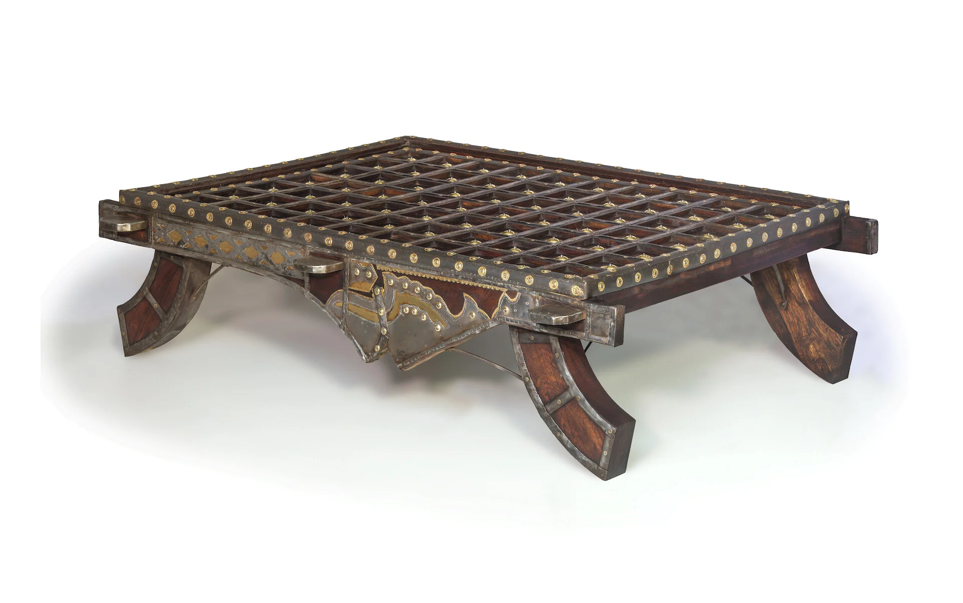 An ornate, antique wooden and metal bed frame with curved legs and intricate decorative details.