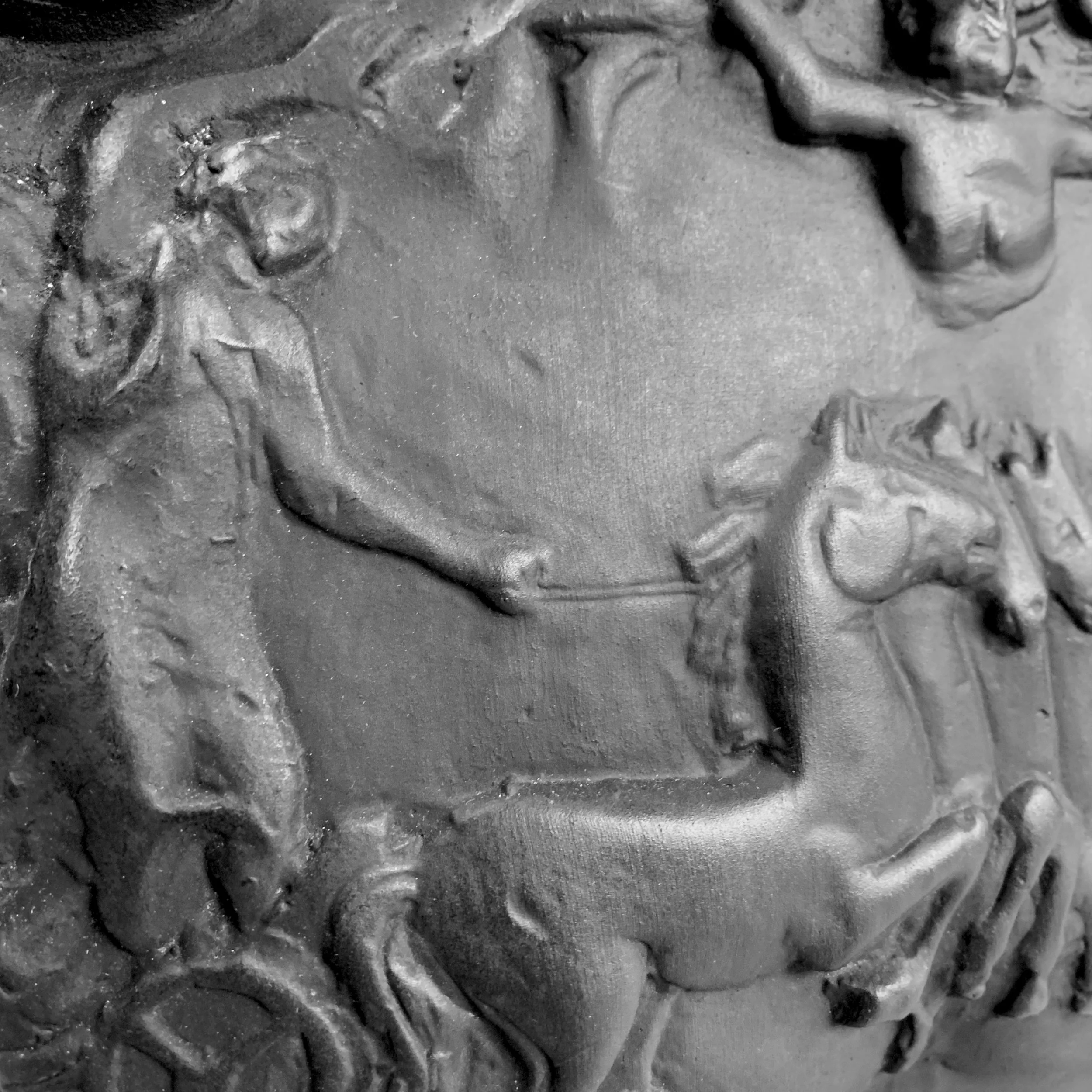 Close-up of a metallic Relief sculpture of a woman with flowing hair and an elaborate headdress or jewelry.