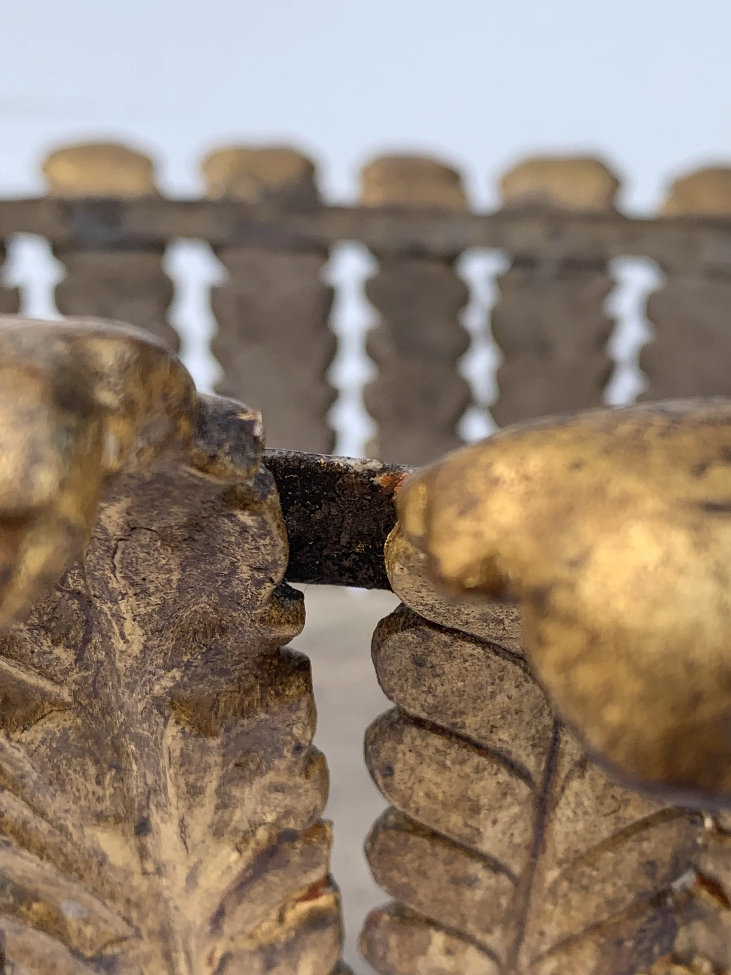 Close-up view of a rusty chain link with a blurred sky background.