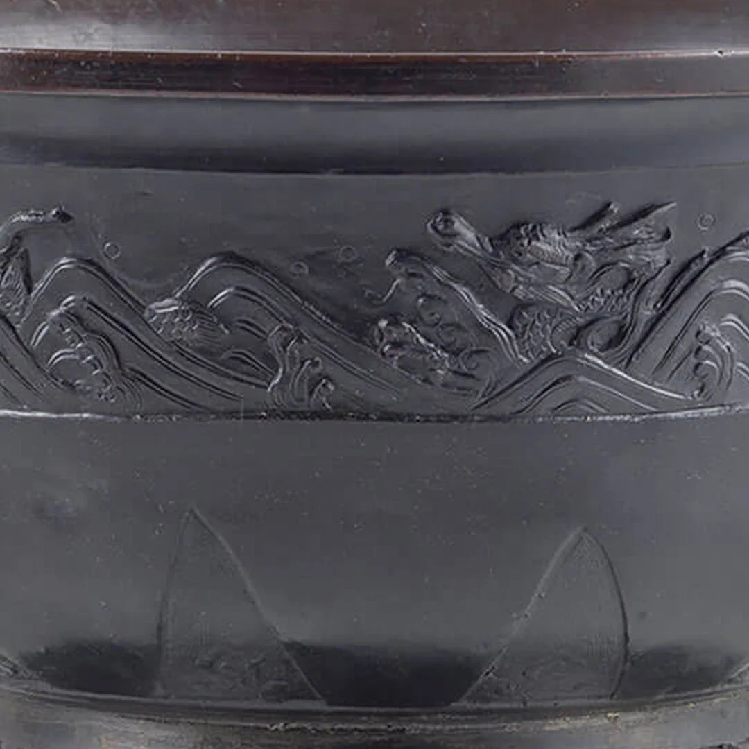 Close-up of a black object with an embossed dragon design.