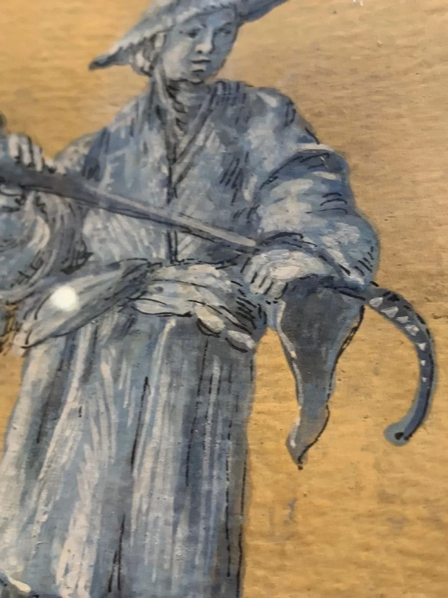 A black and white illustration of a person in traditional Japanese clothing, wearing a headband, holding a long stick, with a cat hanging onto their waist.