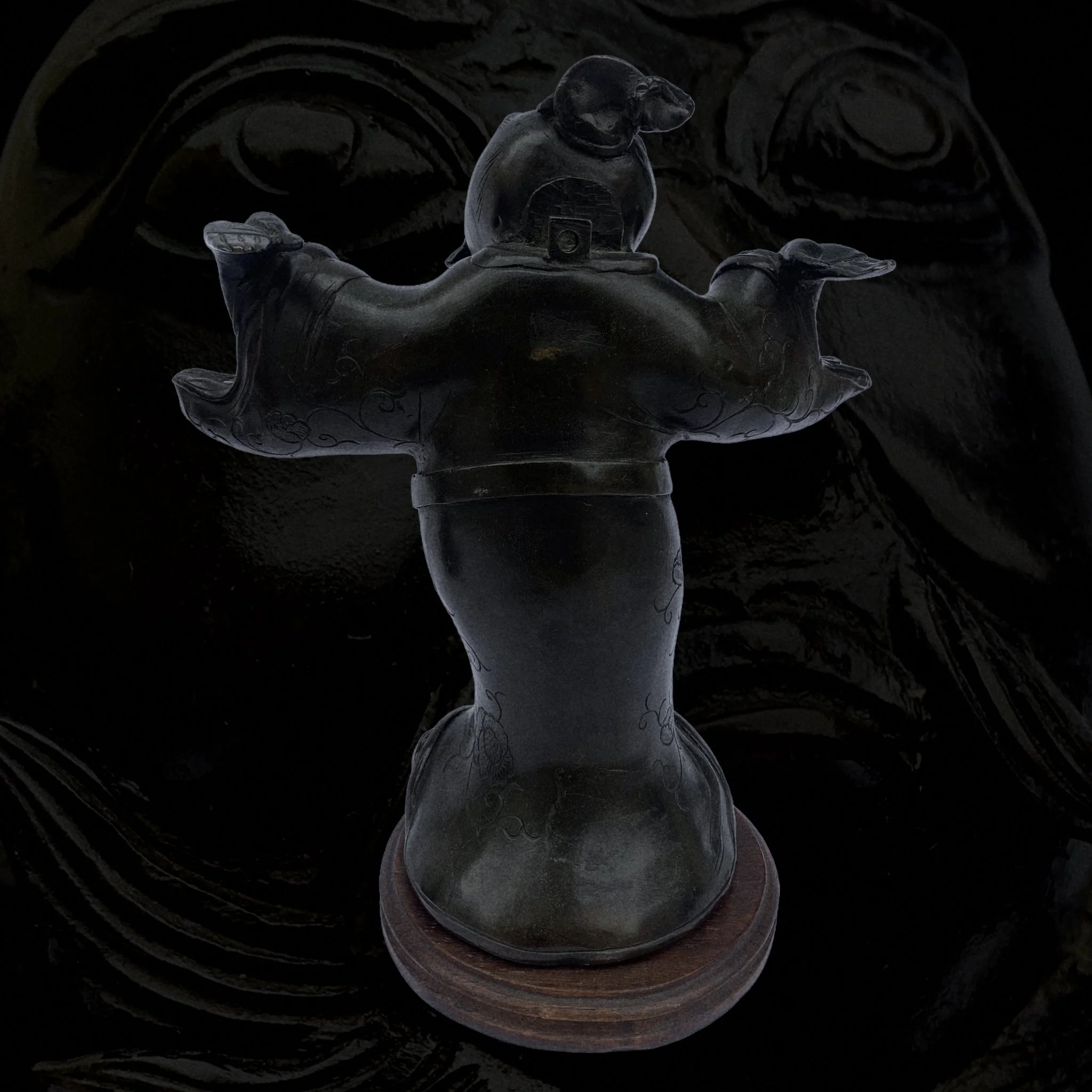 Glass sculpture of a pig wearing a helmet, with wings on its sides, on a wooden base.