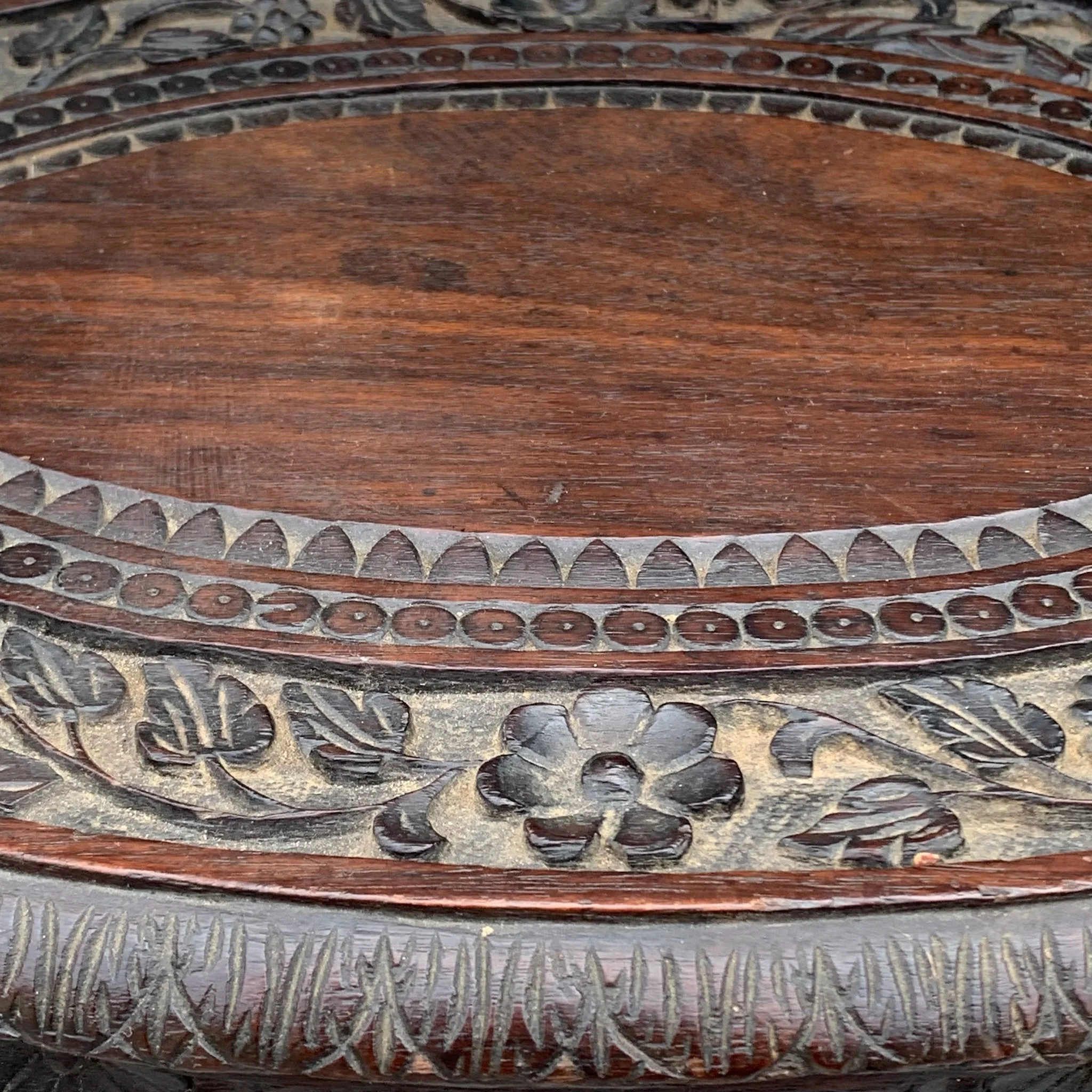 Close-up of a carved wooden surface with floral and geometric patterns.